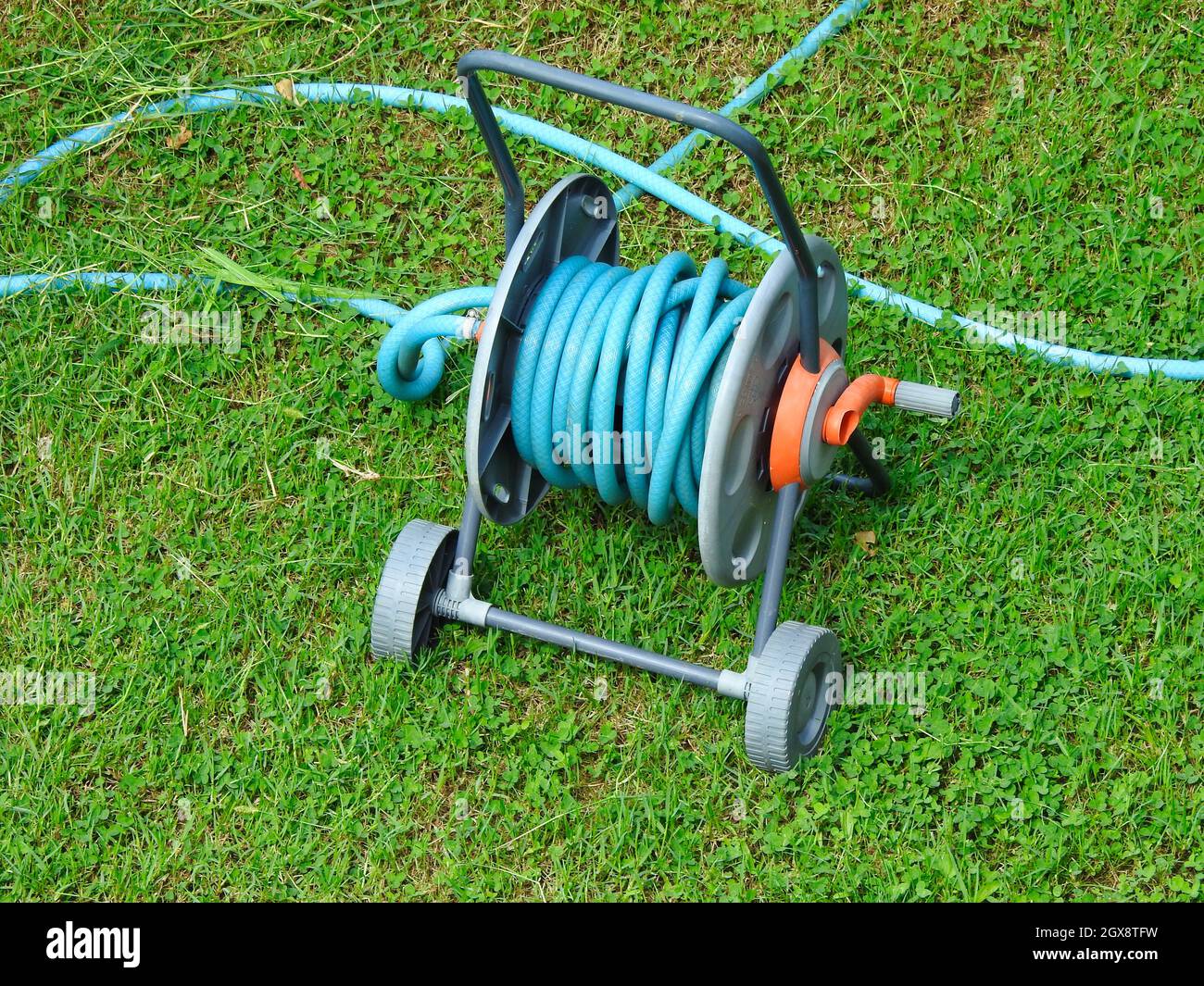 Selfwinding hose reel on green lawn Stock Photo Alamy
