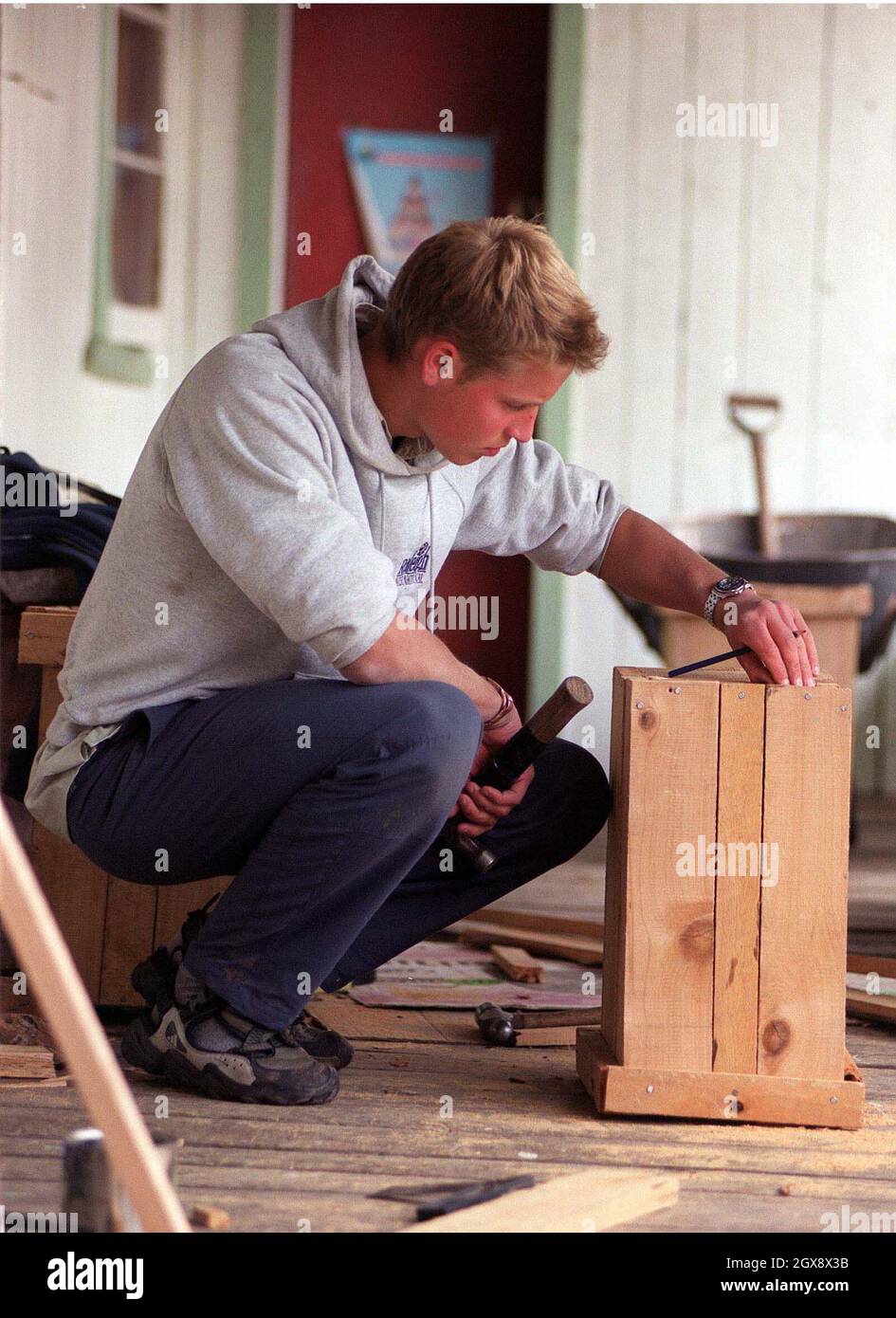 Prince William makes a wooden rubbish bin for the Tortel villagers at the team's accommodation in the village of Tortel, Southern Chile during his Raleigh International expedition in December 2000.  Photo.  Anwar Hussein  Stock Photo