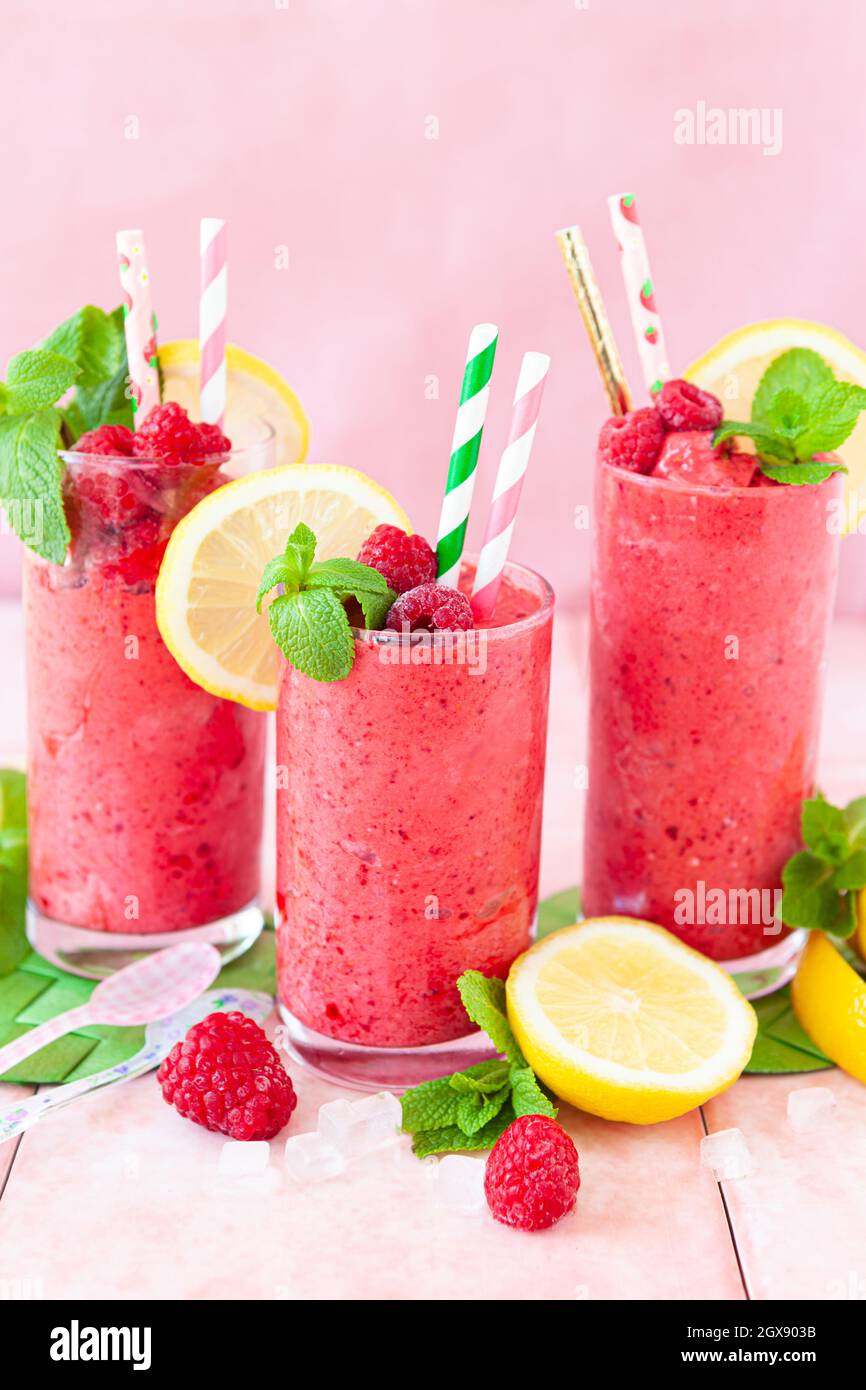 Frozen Smoothie, raspberry sherbet in glasses with fresh lemon and mint Stock Photo