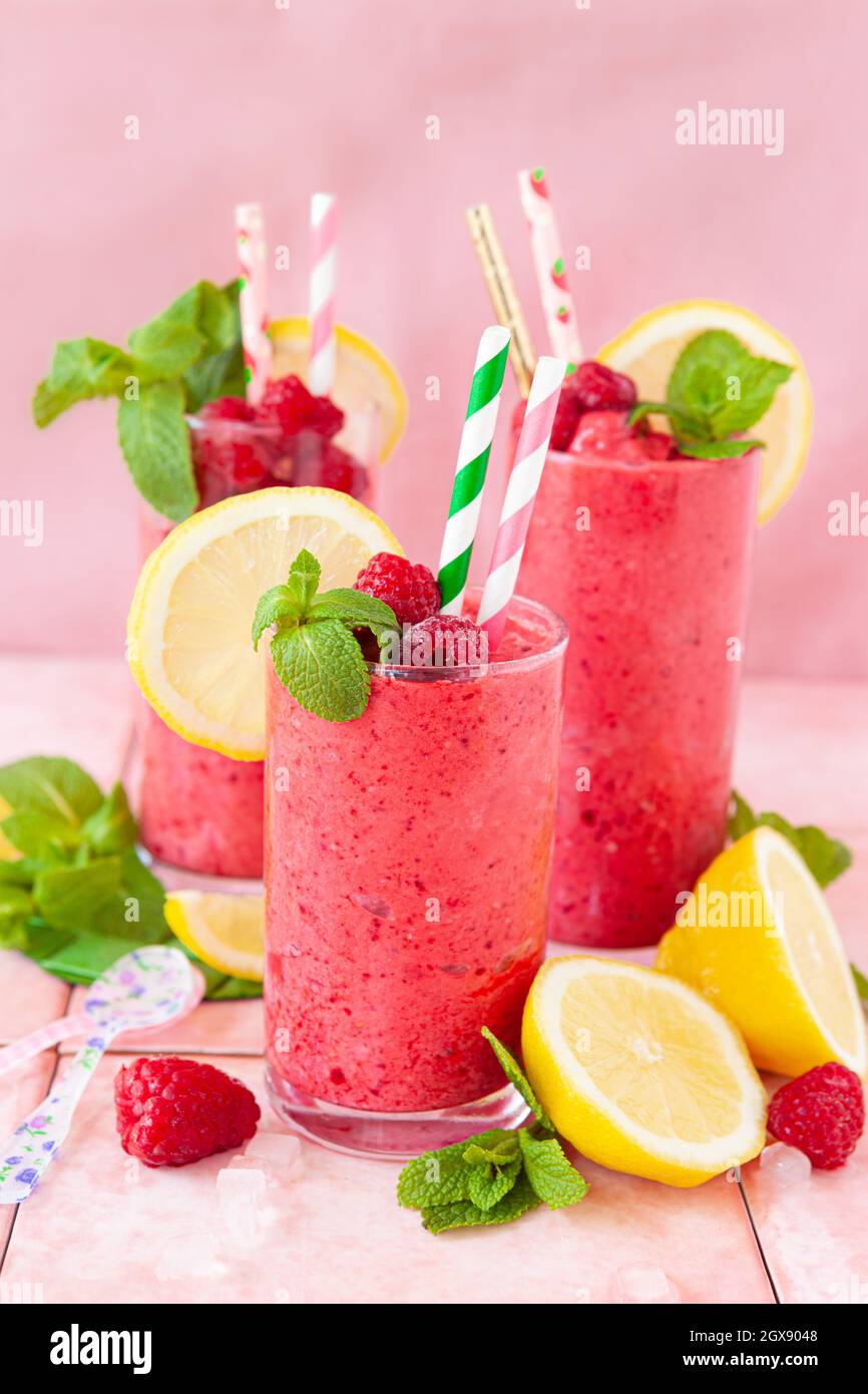 Frozen Smoothie, raspberry sherbet in glasses with fresh lemon and mint Stock Photo