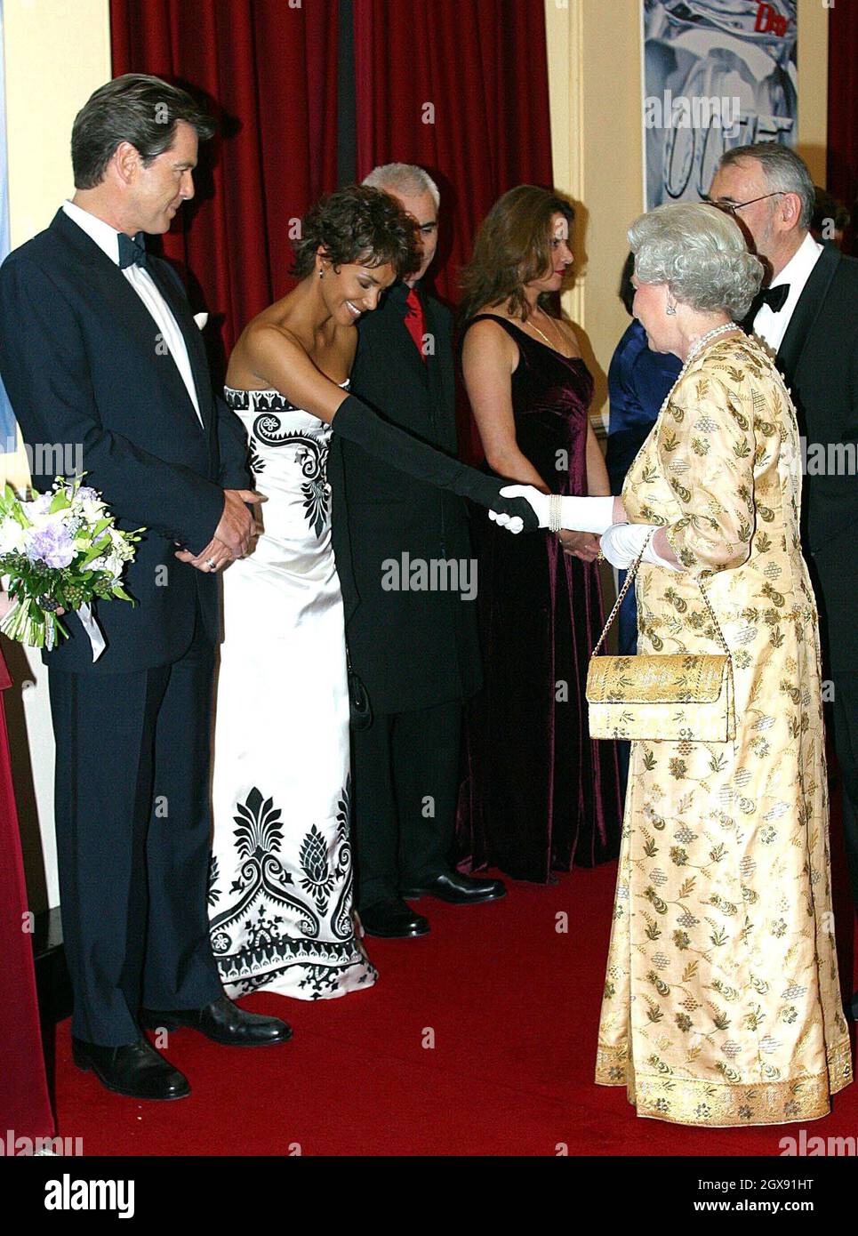 Halle Berry meets Her Majesty Queen Elizabeth II at the World Premiere of  the James Bond film Die Another Day held at London's Royal Albert Hall.  full length. strapless dress. black gloves.