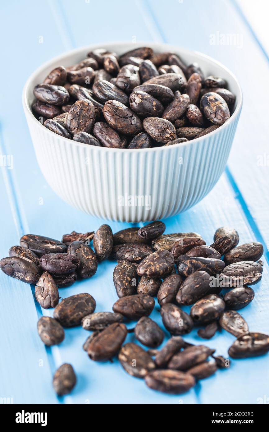 Roasted cocoa beans on blue table Stock Photo