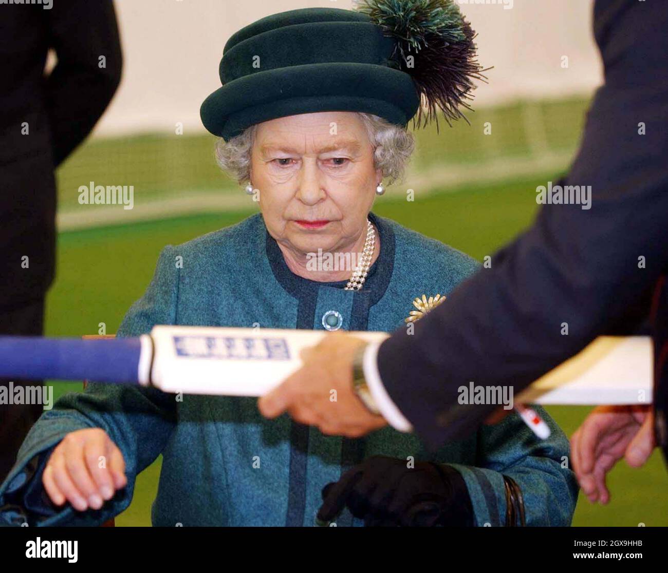 The Queen signs a cricket bat during a visit to the ECB national