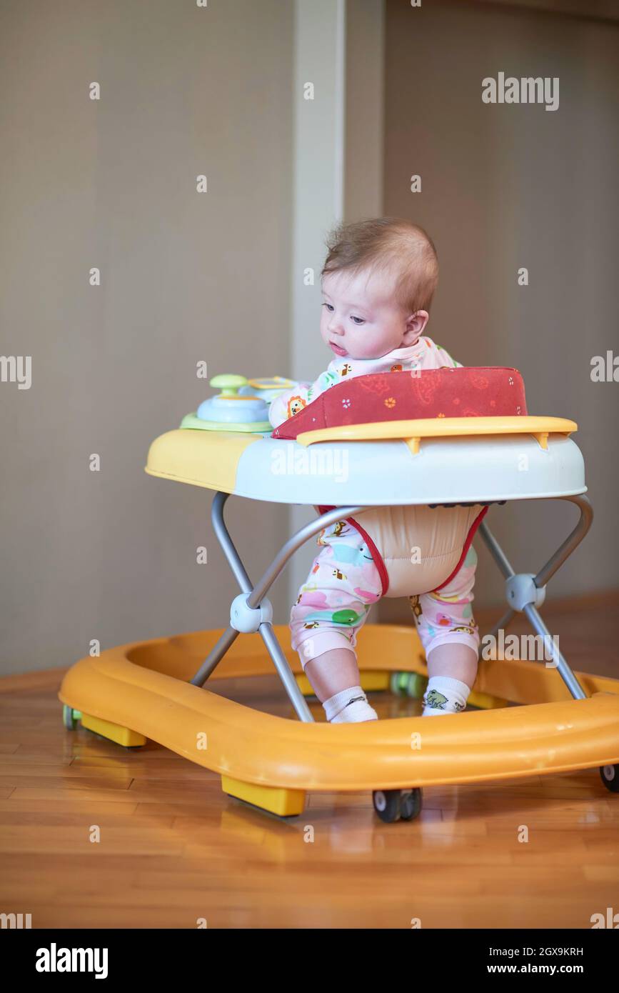 cute little baby learning to walk in walker at home Stock Photo Alamy