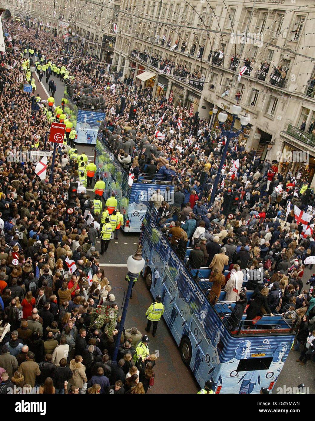 The England rugby team bus makes its way through the thousands of jubilant fans on Regent Street during the World Cup victory parade. Stock Photo