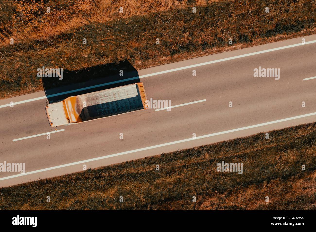 Aerial shot of truck with empty wagon on the road, large vehicle from drone pov Stock Photo