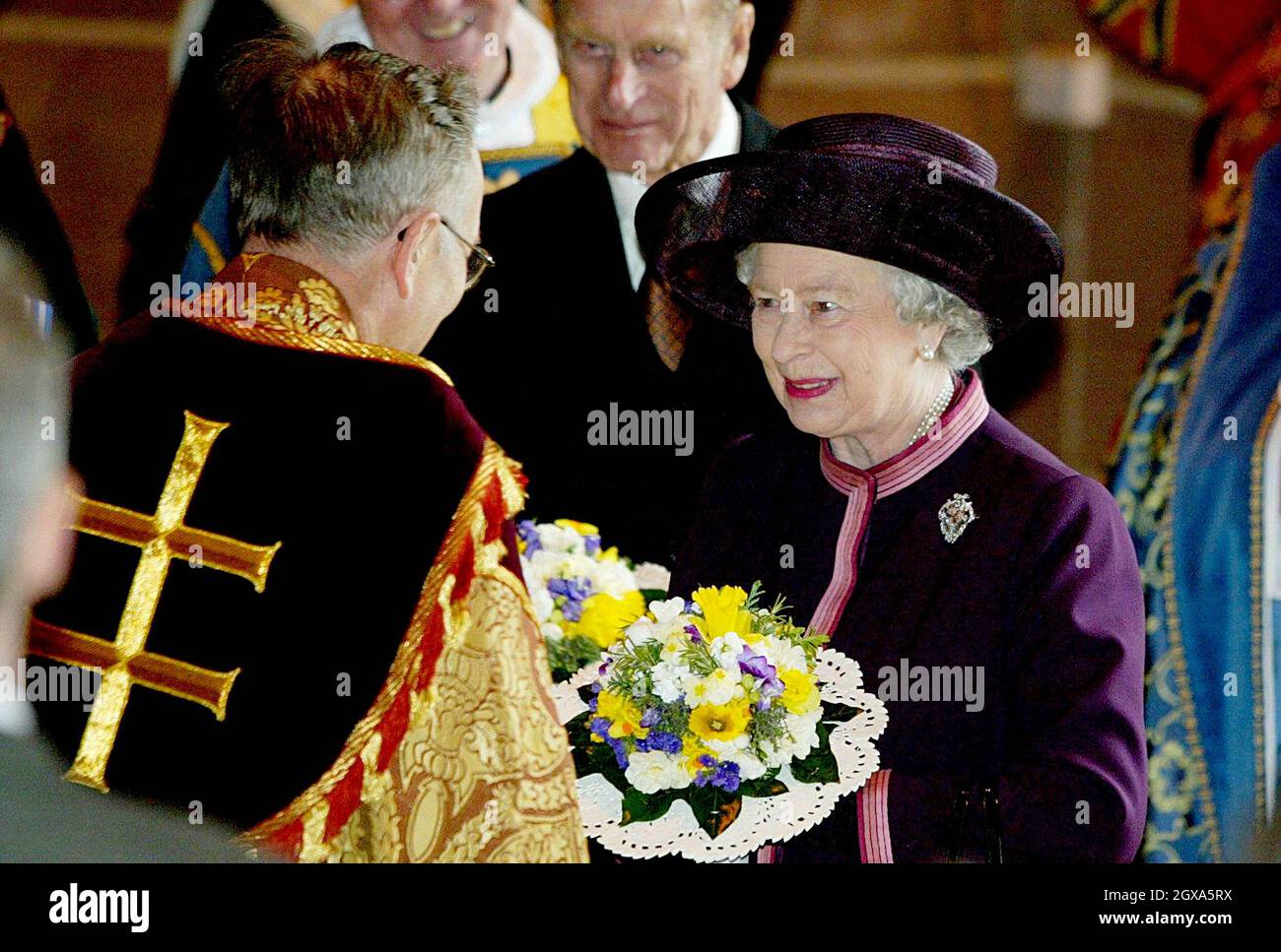 Queen Elizabeth II with the Duke of Edinburgh, is greeted by the Reverend Rupert Hoare, during the Royal Maundy Service held at Liverpool's Anglican Cathedral, Thursday April 8 2004. The Queen arrived in Liverpool today wearing a purple suit with a pink trim and matching hat, to take part in the ancient Maundy Thursday ceremony.    Stock Photo