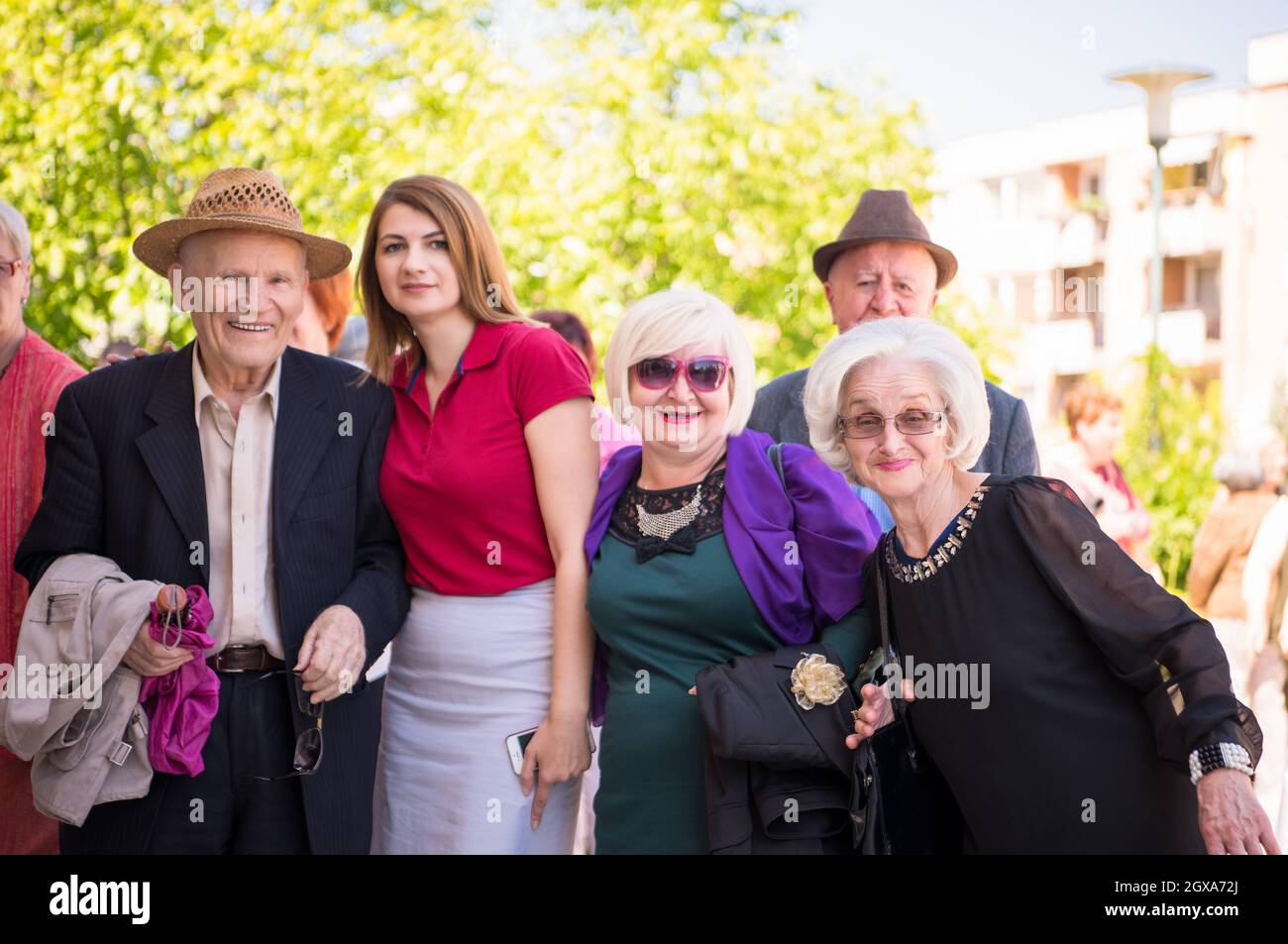 group portrait of senior people with geriatric nurse at park in front of a retirement home Stock Photo