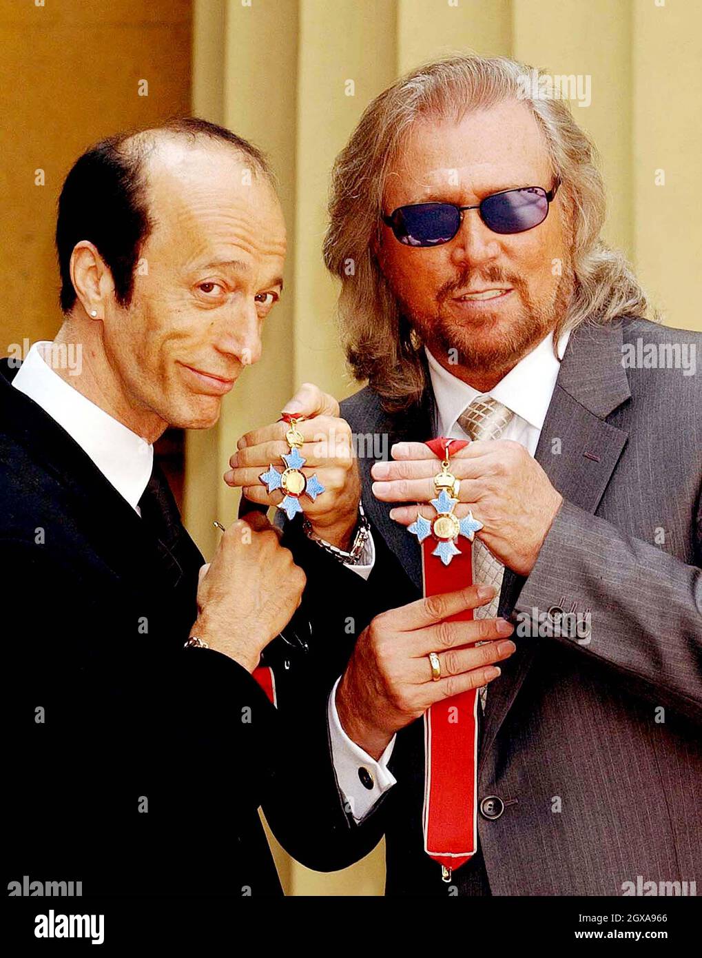 The two surviving members of the Bee Gees, Robin (left) and Barry Gibb hold their CBE's after receiving them from the Prince of Wales at Buckingham Palace, London, Thursday May 27, 2004. The third brother, Maurice Gibb, died last year before he could receive the honour and so his son Adam collected it on his behalf.   Stock Photo