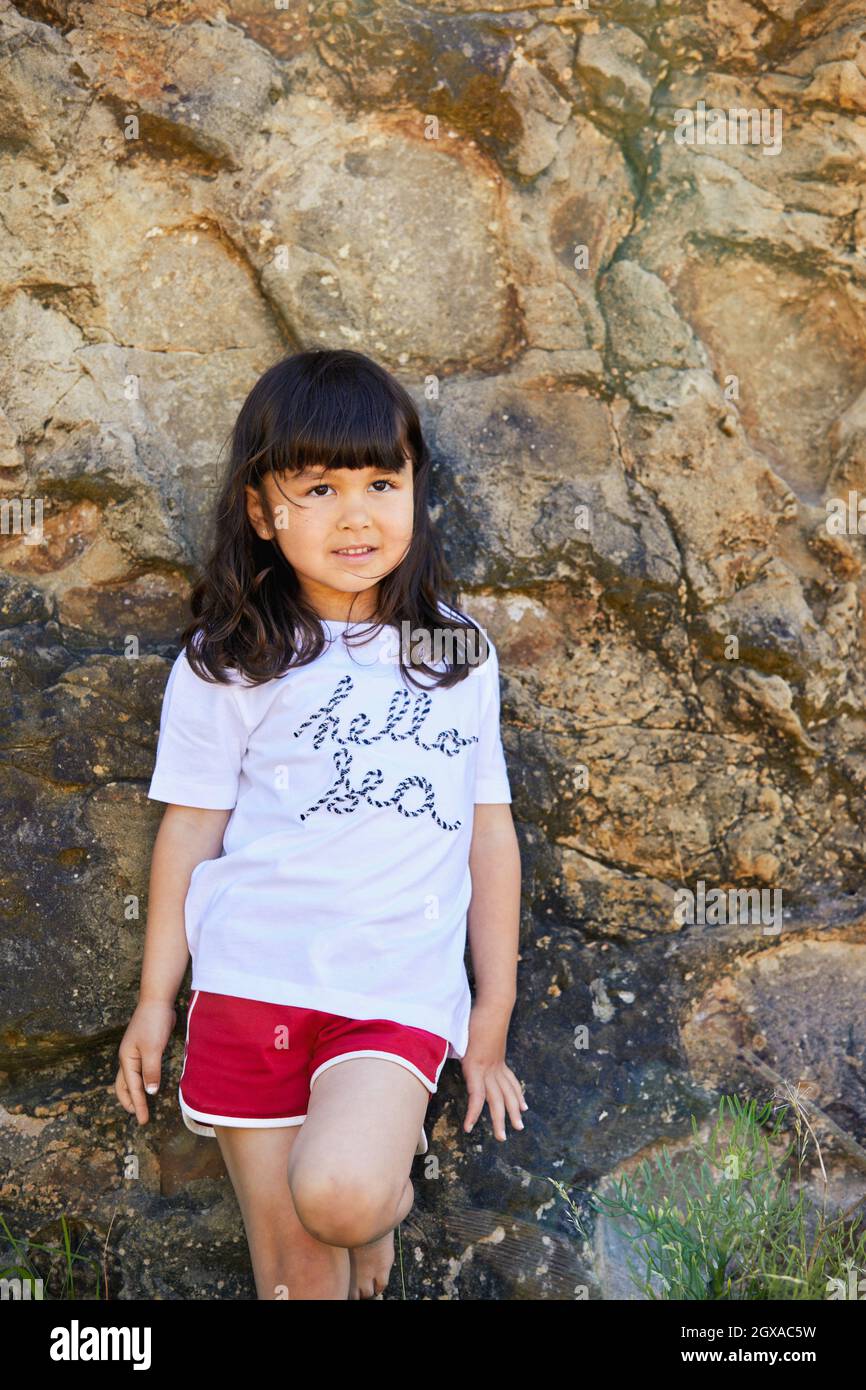 Girl 5-10 years on the rocks, Zumaia, Gipuzkoa, Basque Country, Spain Stock Photo