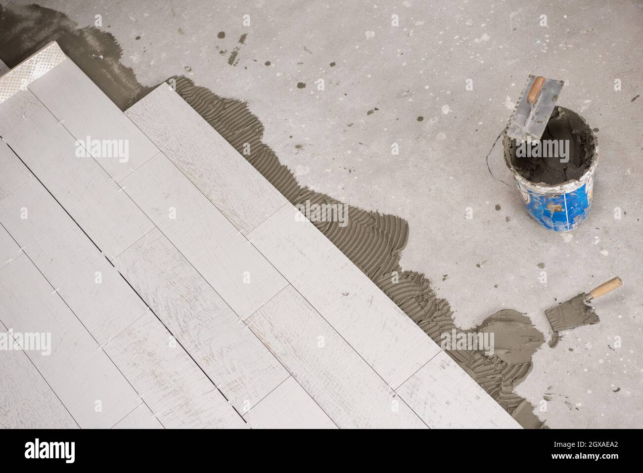 Ceramic wood effect tiles and tools for tiler on the floor unfinished