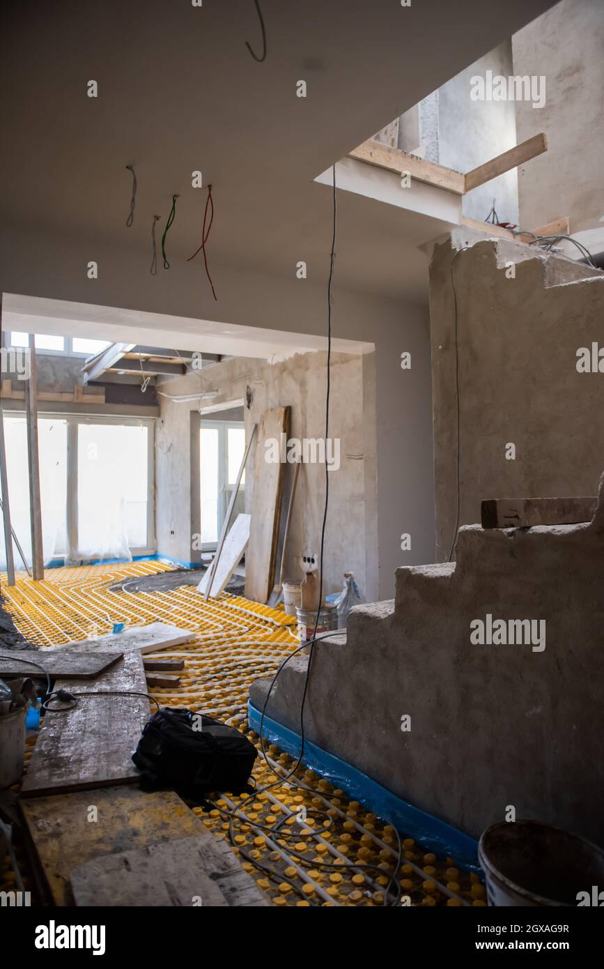 Image showcasing yellow underfloor heating installation with white polyethylene pipes on ...