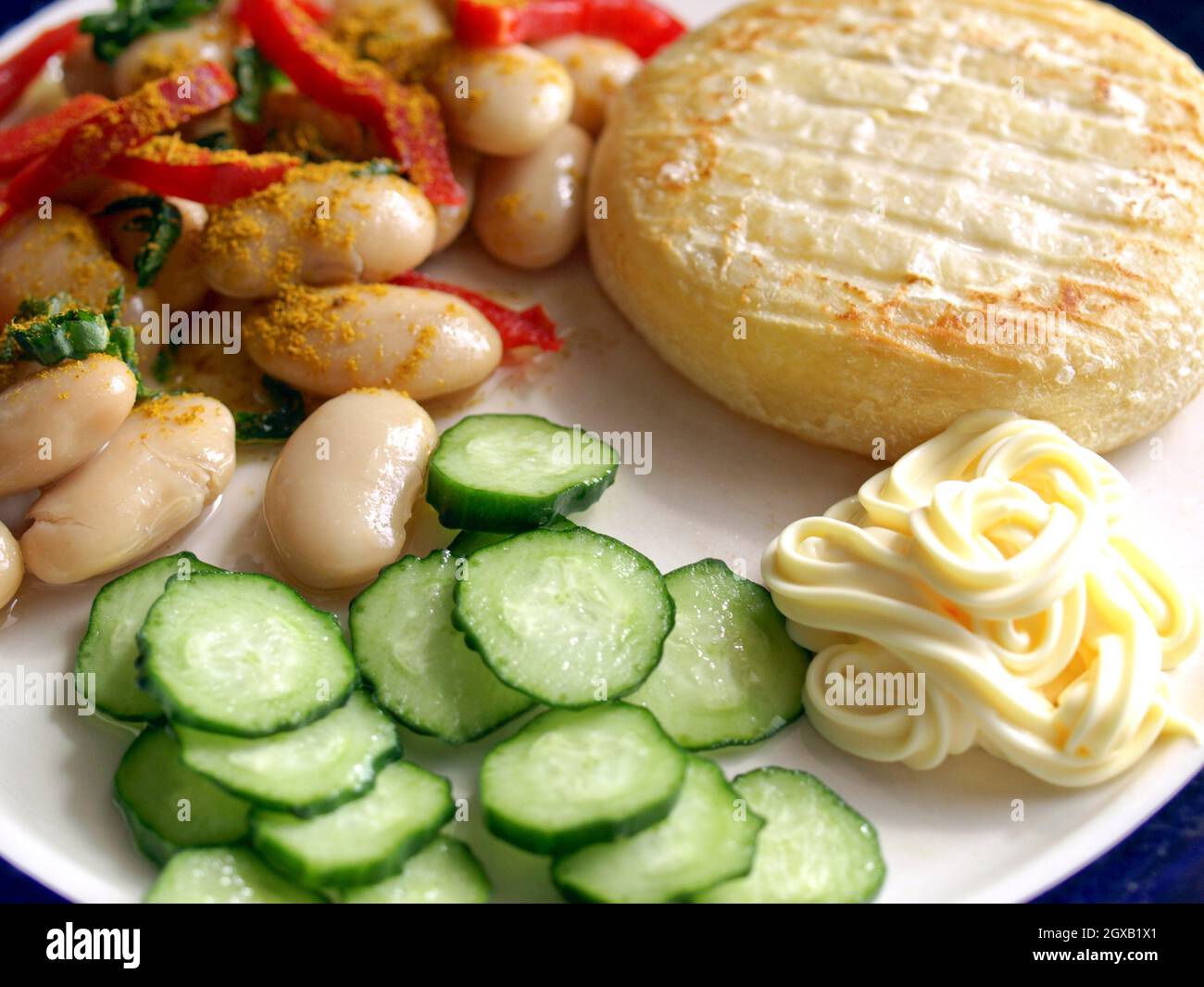 Vegetarian main dish including cheese, mayonnaise, curry beans, peppers and cucumbers. Stock Photo