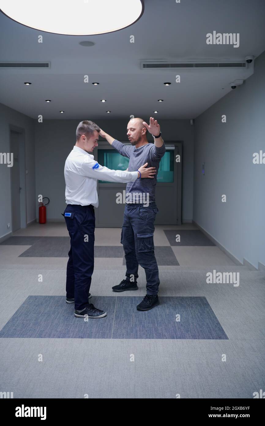 Security guard making body searching procedure on man for finding