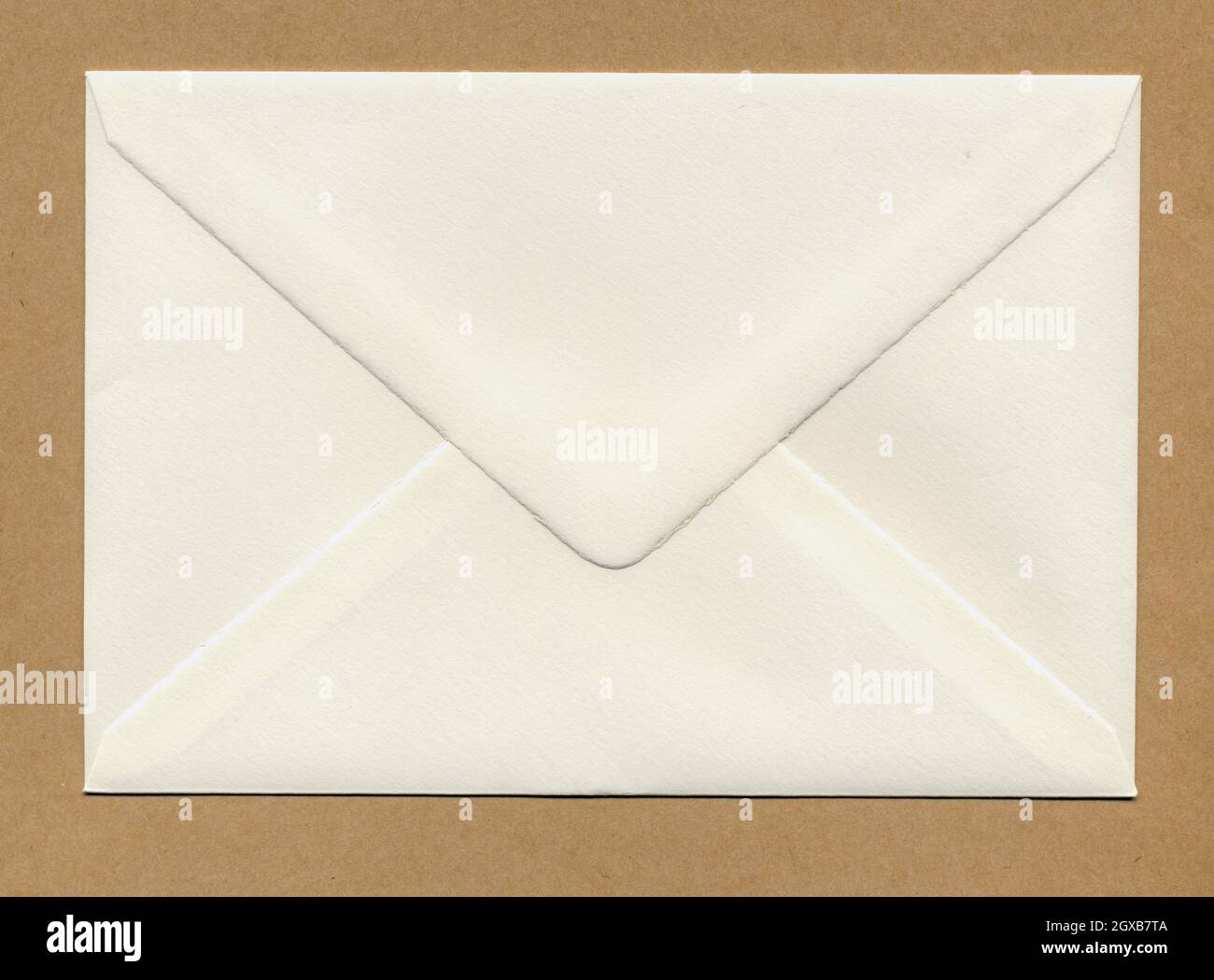 a letter envelope for mail postage shipping over brown paper. Stock Photo