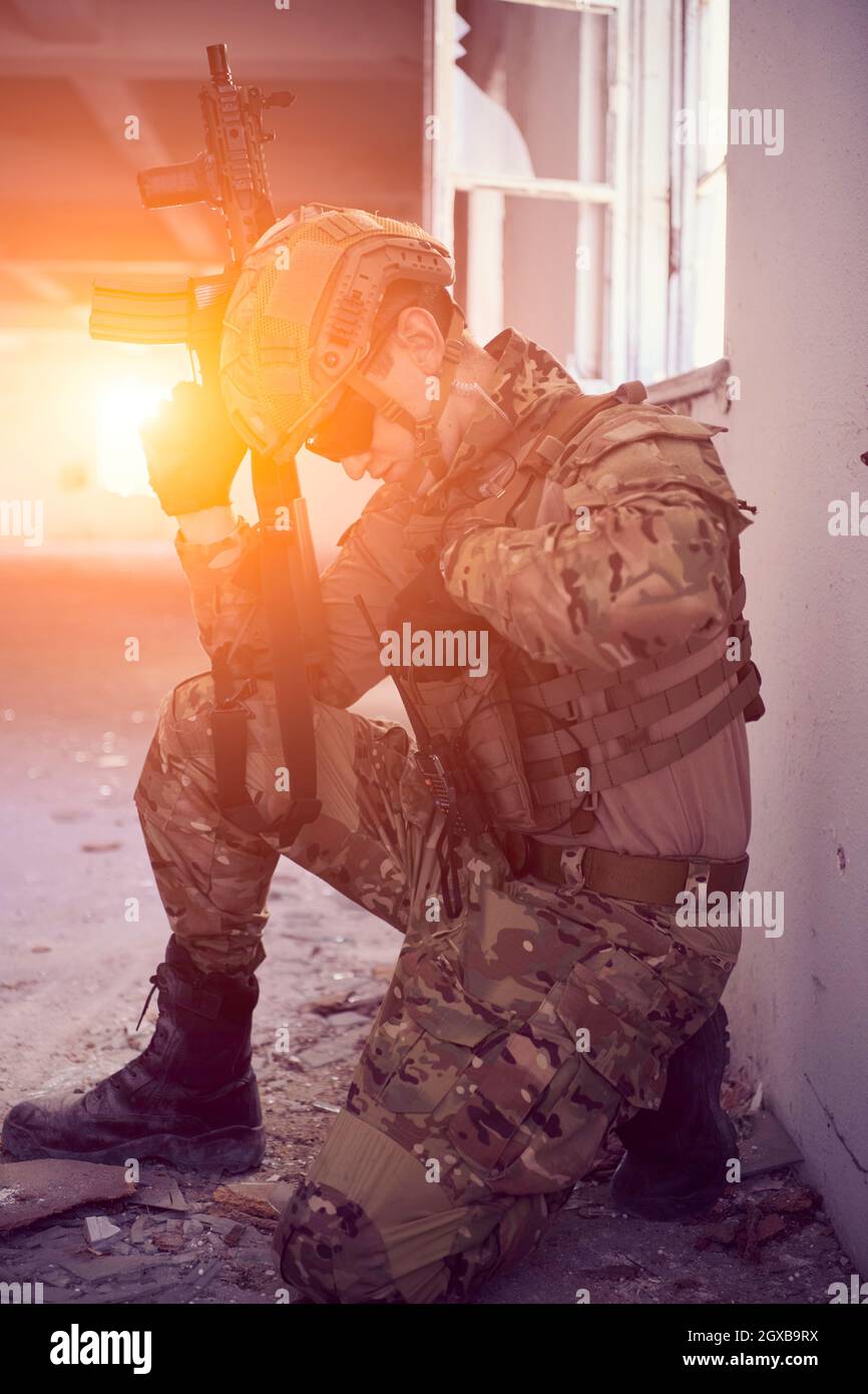 modern warfare soldier in action near window changing magazine and take