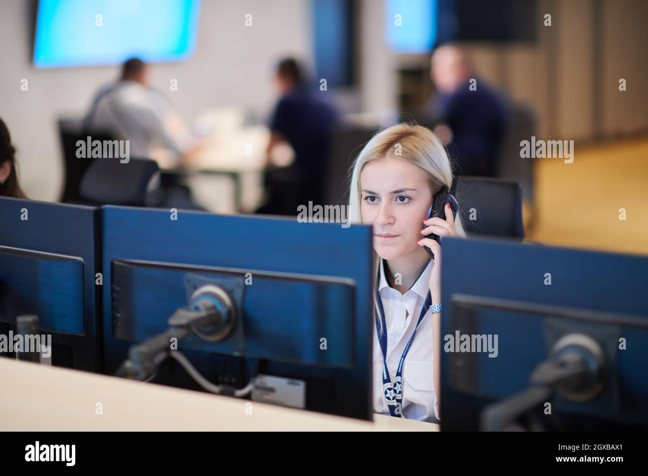 Female security guard operator talking on the phone while working at ...