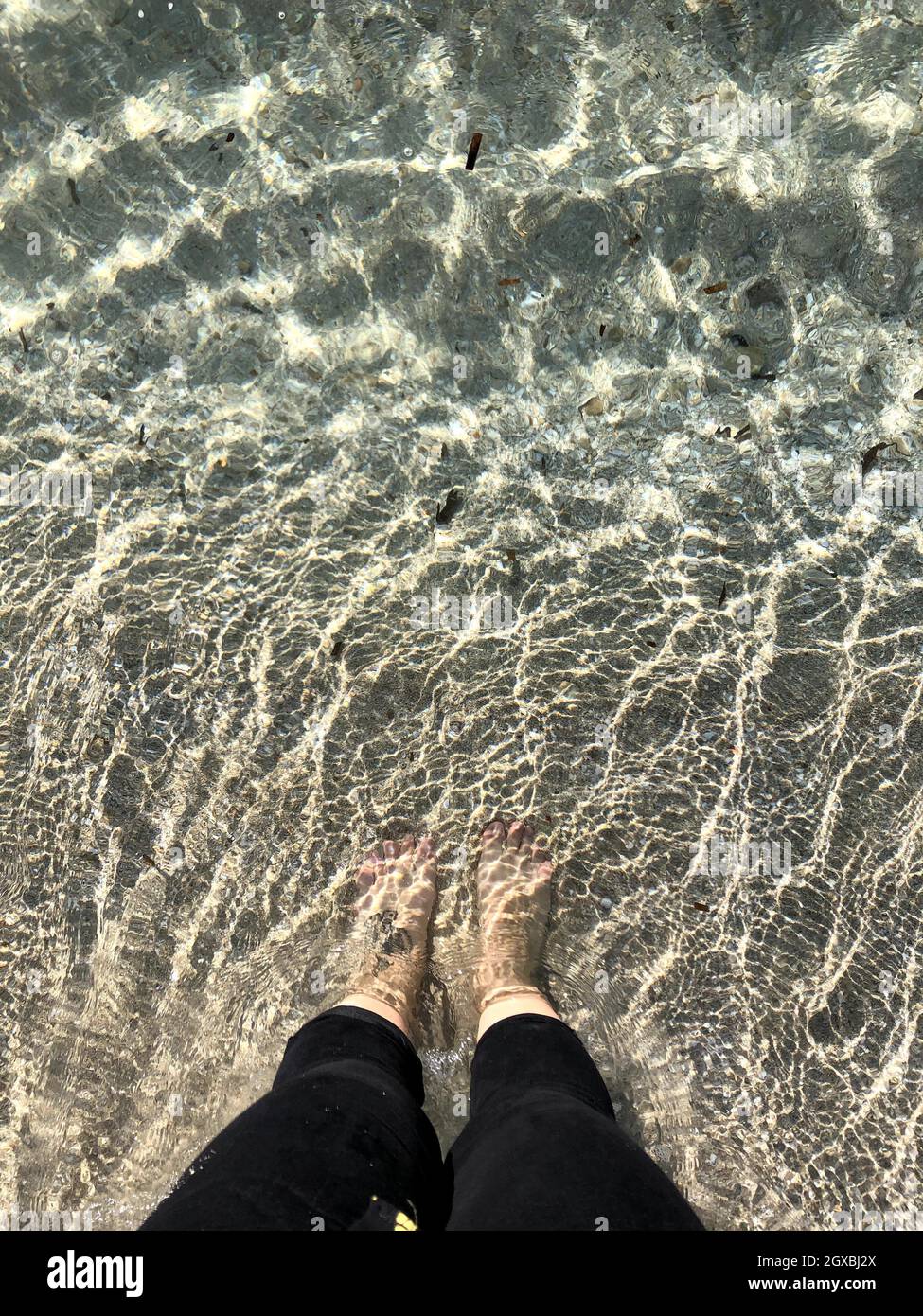 Overhead view of a woman standing in sea paddling, Majorca, Spain Stock