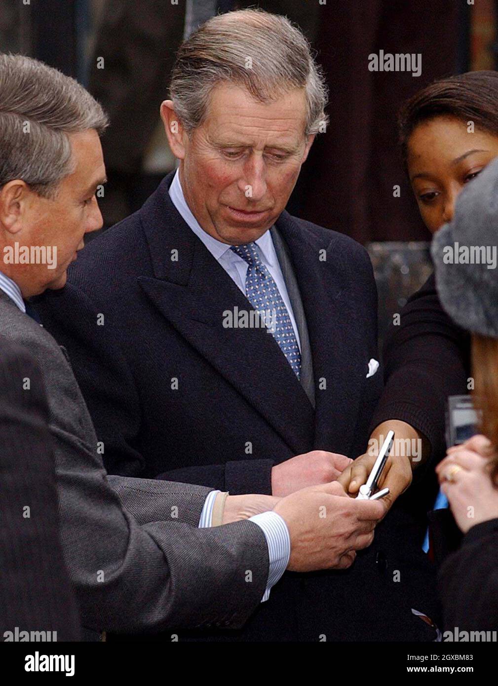 The Prince of Wales is shown how a camera phone works after posing for ...