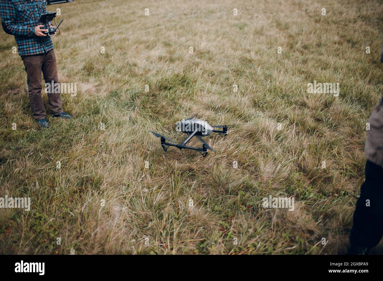 Man pilot controlling quadcopter drone with remote controller pad. Stock Photo