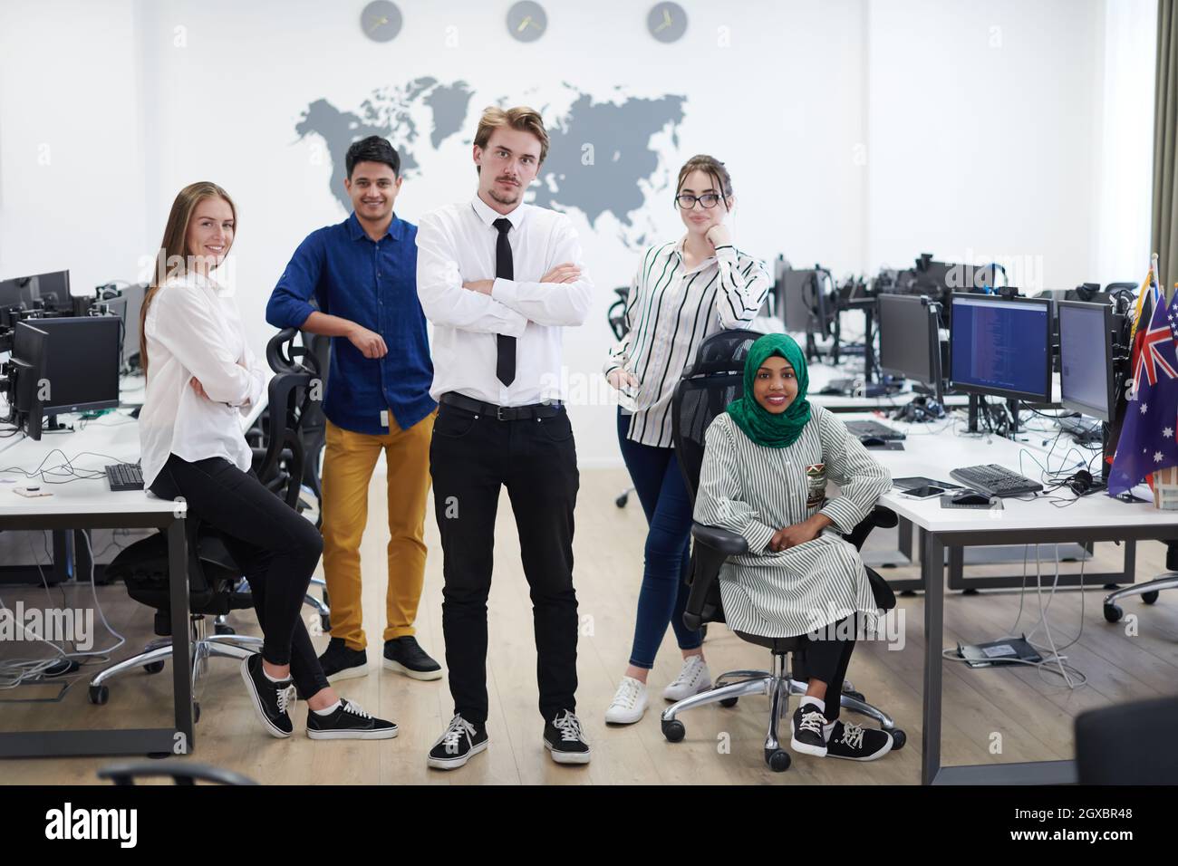 portrait of young excited multiethnics business team of software developers standing and looking at camera at modern startup office Stock Photo
