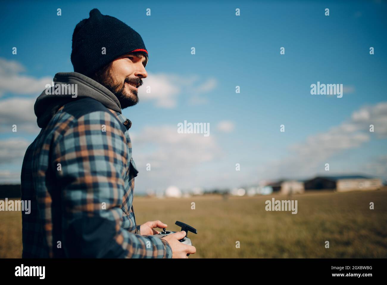 Man pilot controlling quadcopter drone with remote controller pad. Stock Photo