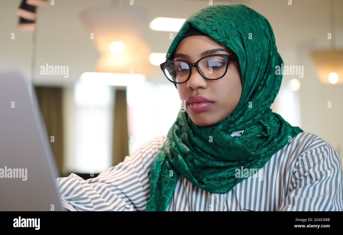 african muslim business woman wearing a green hijab while working on ...