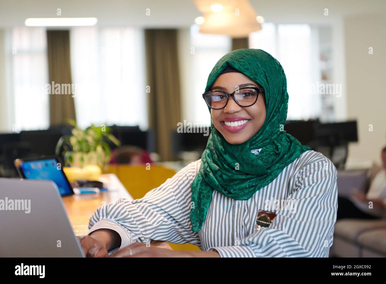 african muslim business woman wearing a green hijab while working on ...