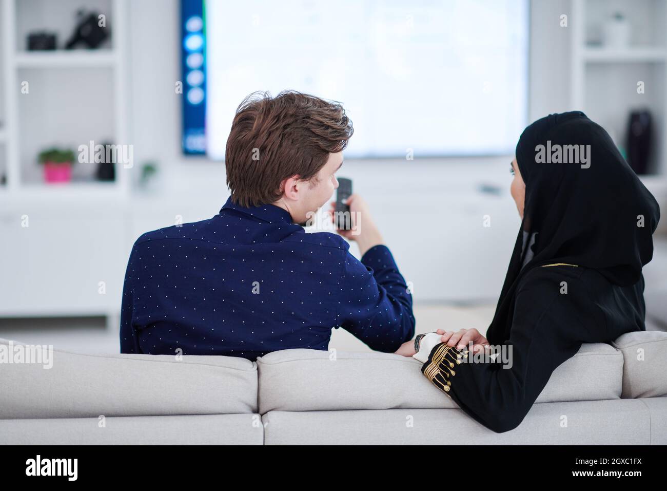 young muslim couple woman wearing islamic hijab clothes sitting on sofa ...