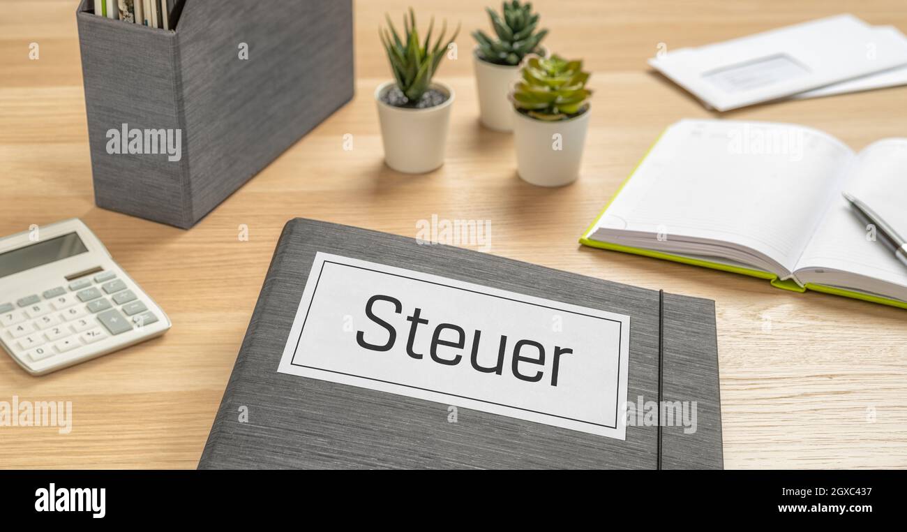 A folder on a desk with the label Taxes in german - Steuer Stock Photo