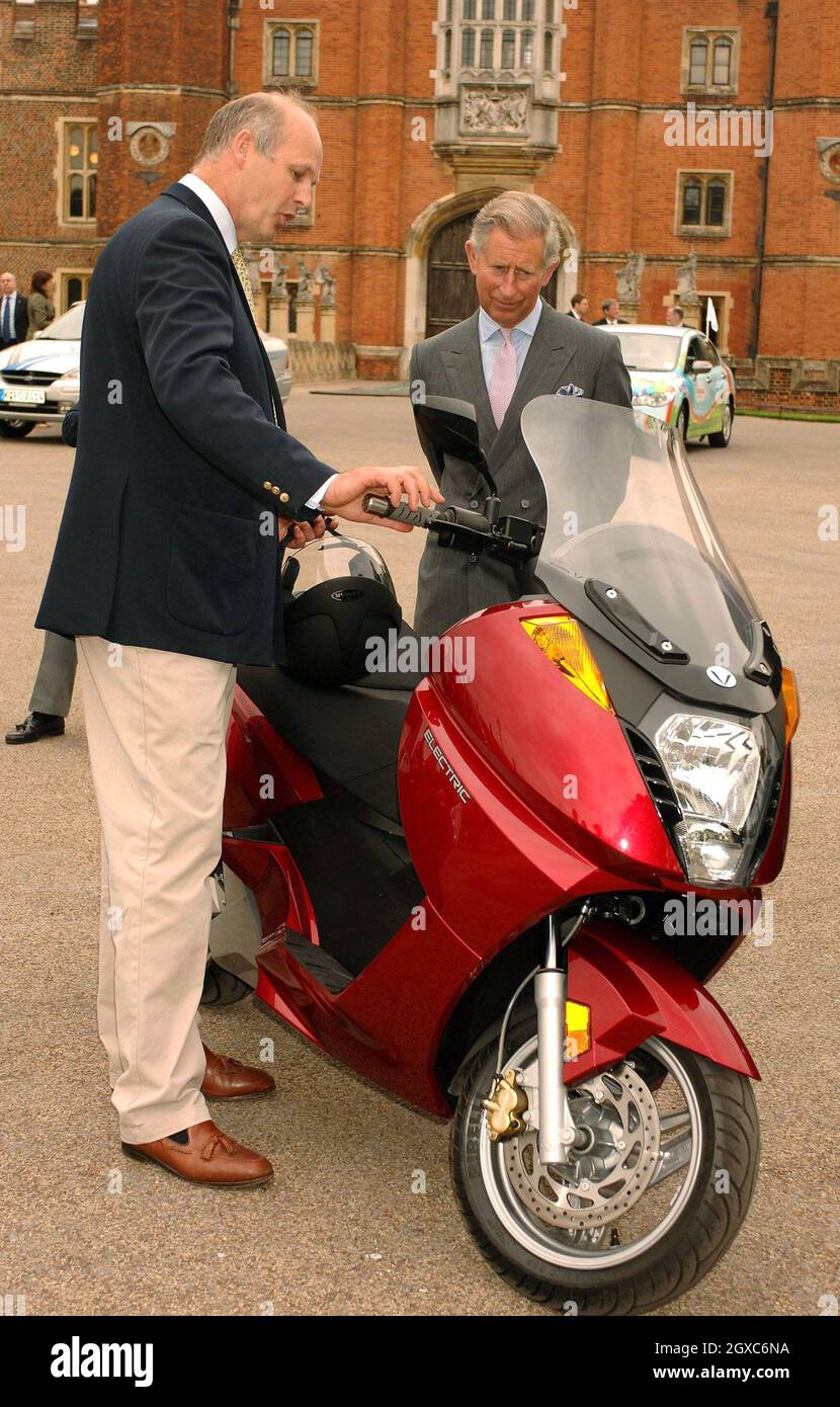 Prince Charles, Prince of Wales examines a Vectrix electric eco-friendly scooter with Alex Bamberg of Vectrix UK during a test drive around the car park of the Hampton Court Palace on June 4, 2007. The Royal test drive took place ahead of the Brighton to London Eco-Car Rally tomorrow. Stock Photo