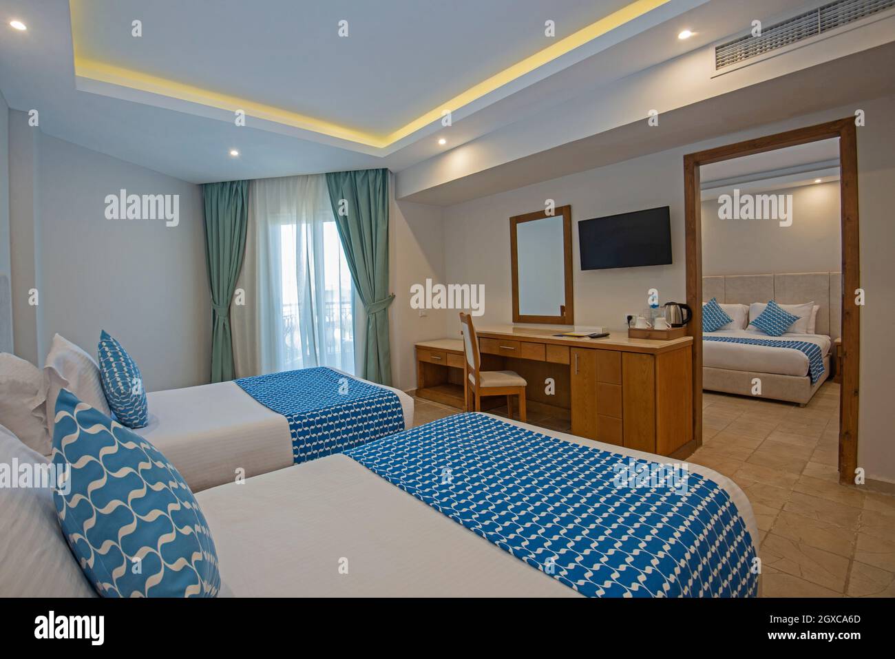 Twin beds in family room suite at a luxury hotel with adjoining bedroom