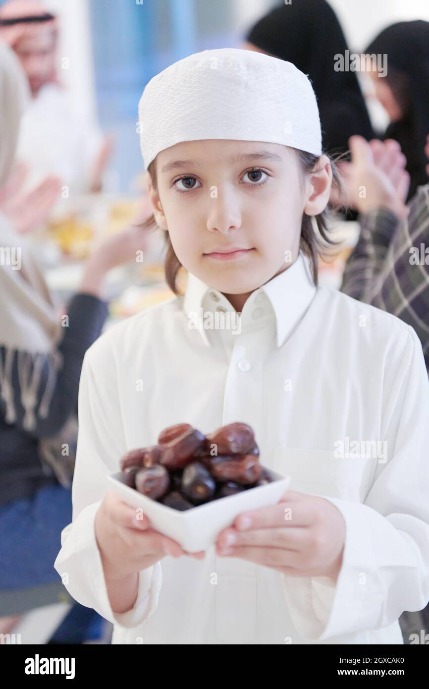 Eid Mubarak Muslim family having Iftar dinner little boy holding a