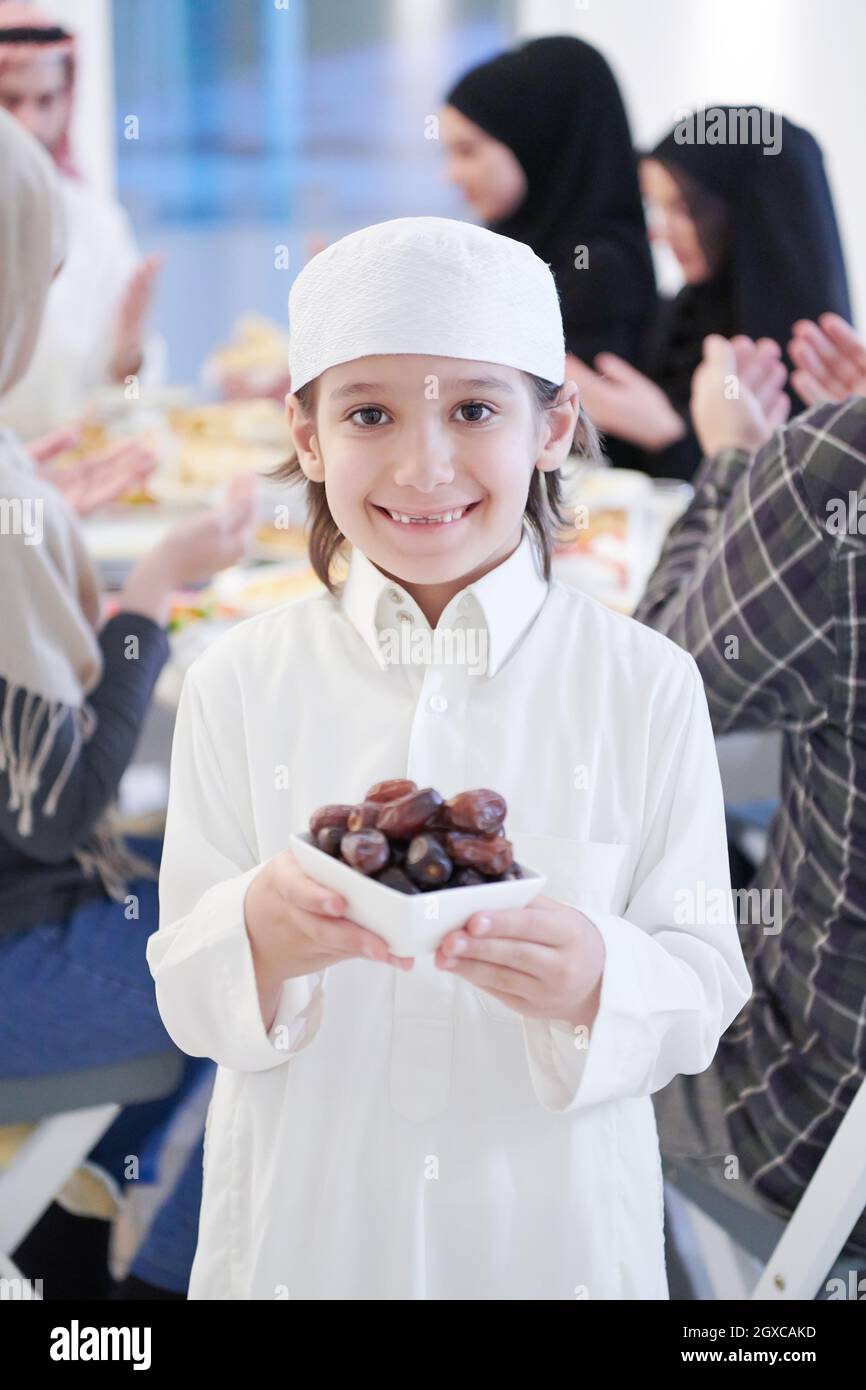 Eid Mubarak Muslim family having Iftar dinner little boy holding a