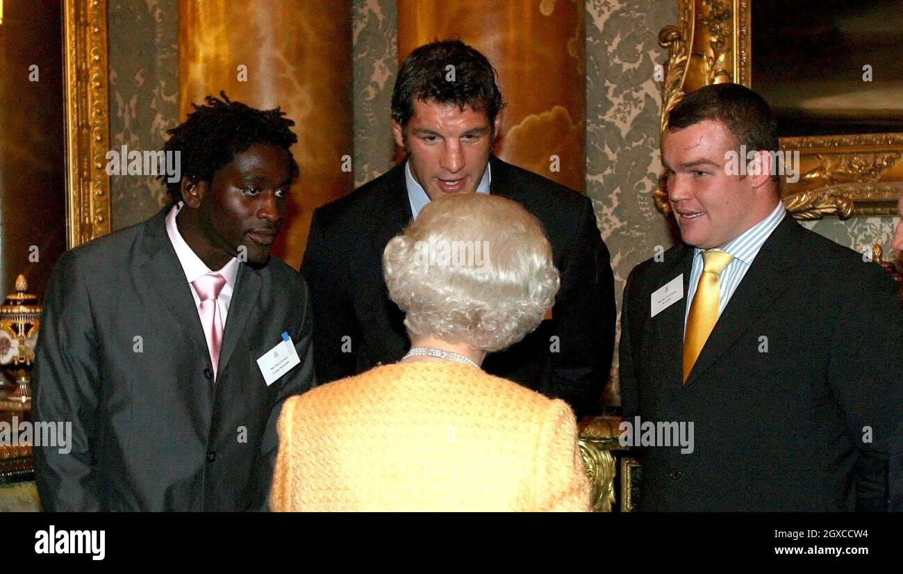 Queen Elizabeth II meets rugby players (from left to right) Paul Sackey, Simon Shaw and Matt Stevens at a reception for Commonwealth Africans in Buckingham Palace, London. Stock Photo