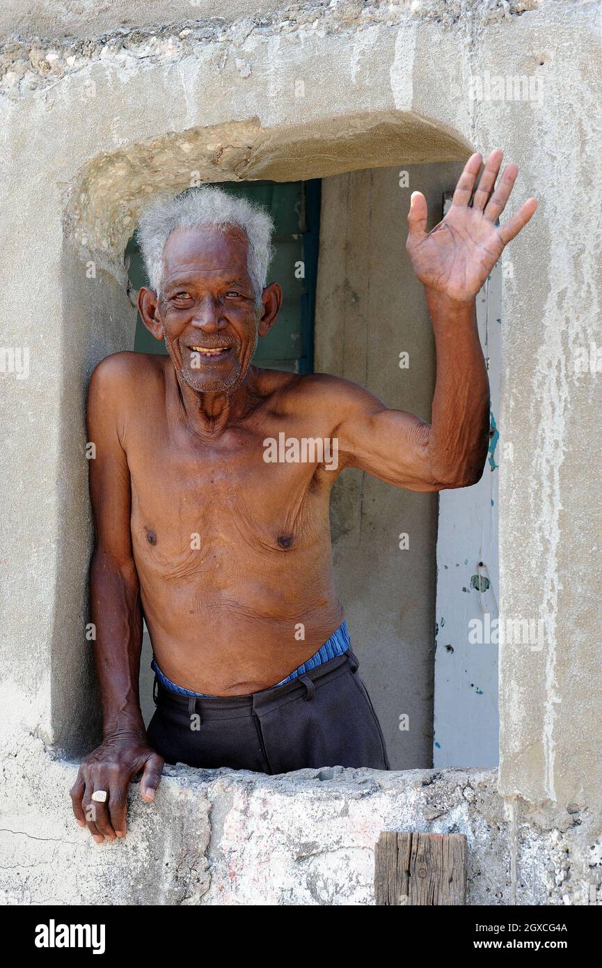 A local man waves from his window as Prince Charles, Prince of Wales and Camilla, Duchess of Cornwall visit the historic town of Falmouth in Jamaica. Stock Photo