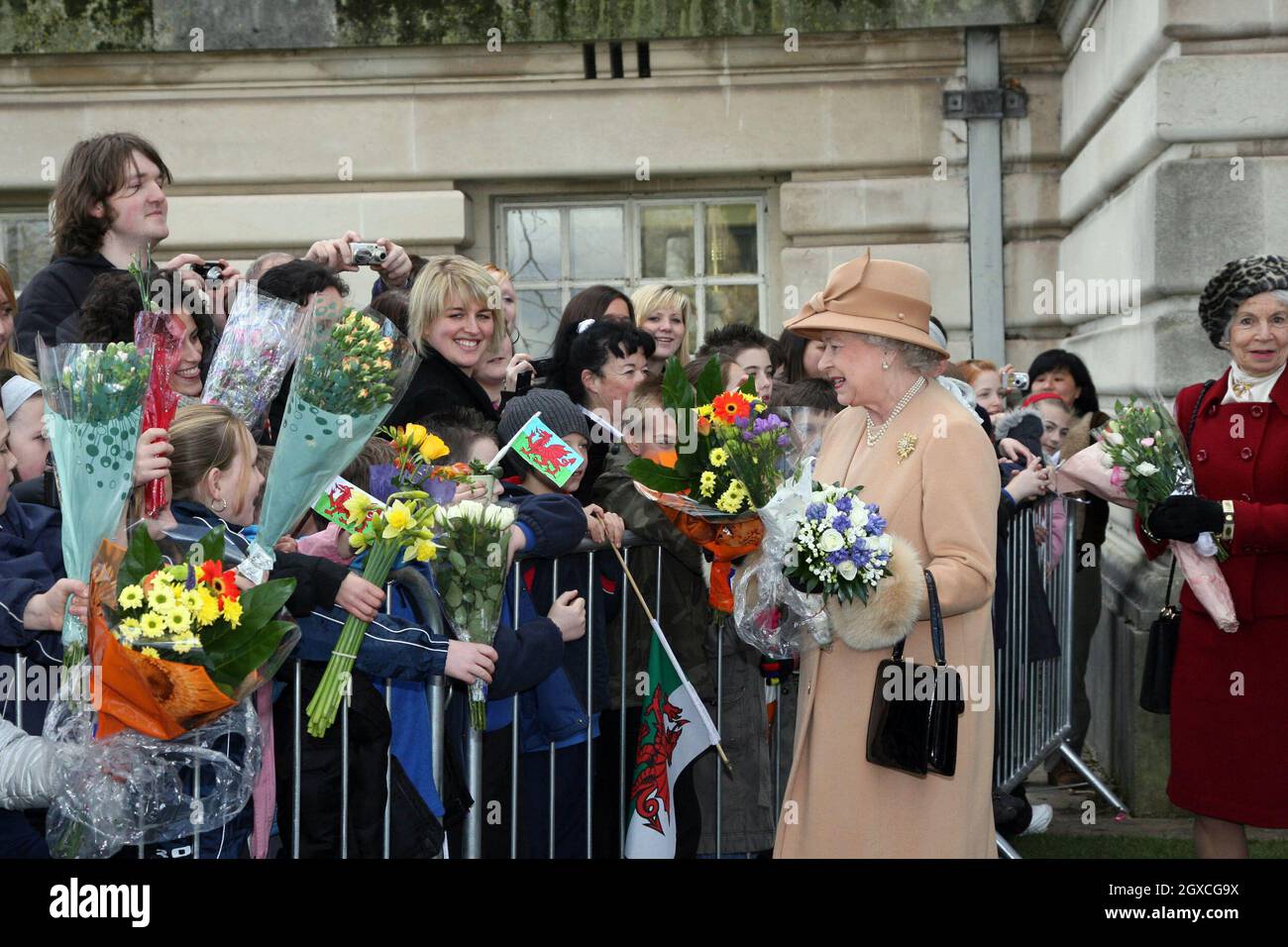 Queen Elizabeth II receives bouquets of flowers from local children when she visits the Guildhall in Swansea. Stock Photo