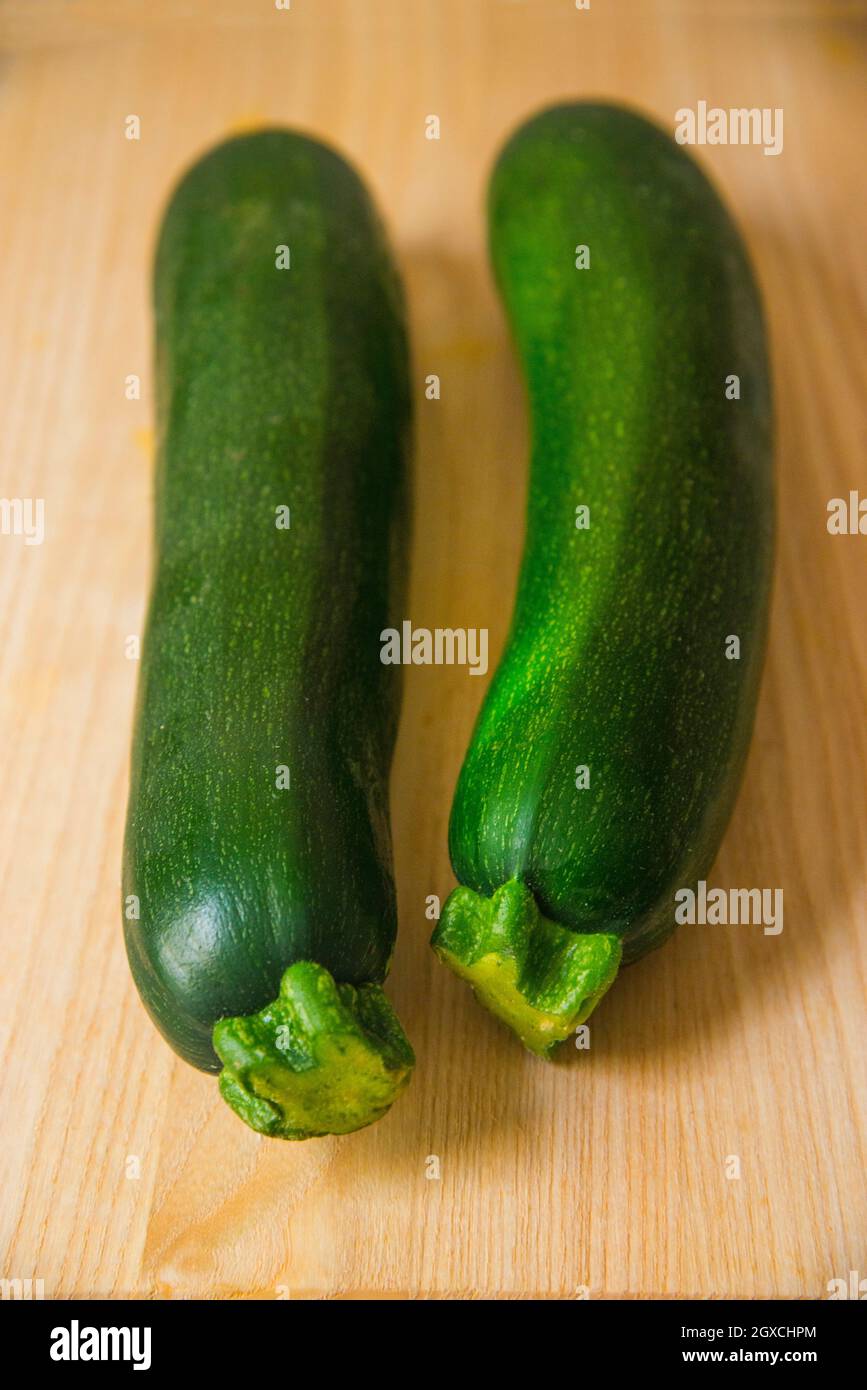 Two courgettes on wooden surface. Still life. Stock Photo