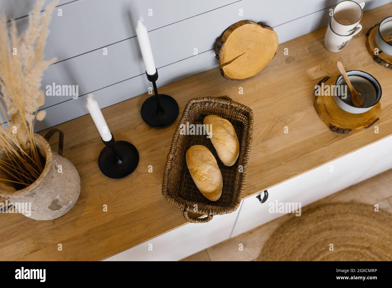 Two French bread rolls in a wicker basket on the Scandinavianstyle kitchen countertop Stock