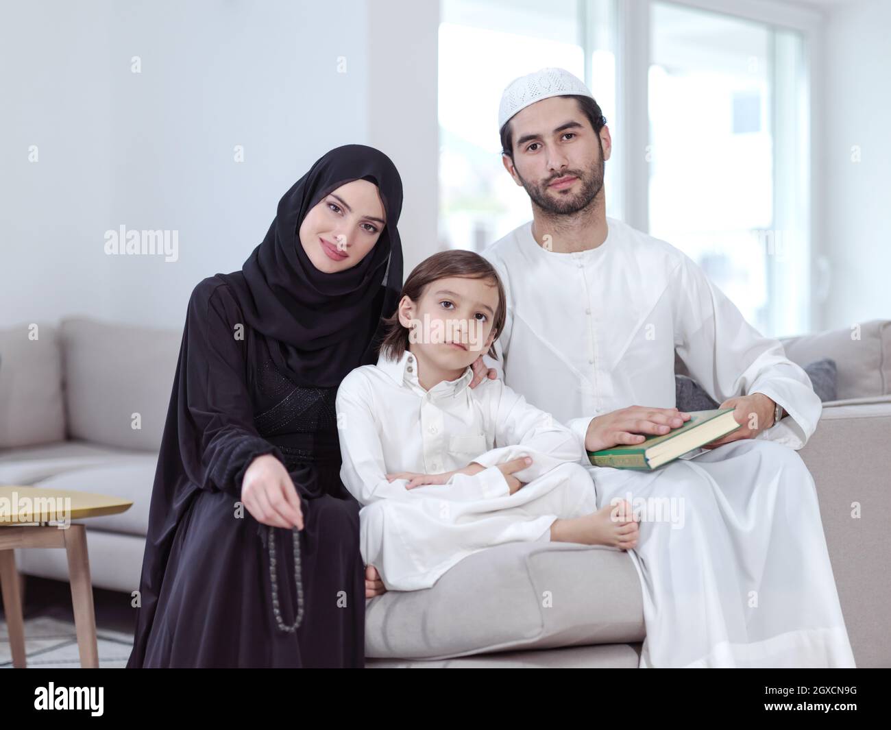 Traditional muslim family parents with children reading Quran and