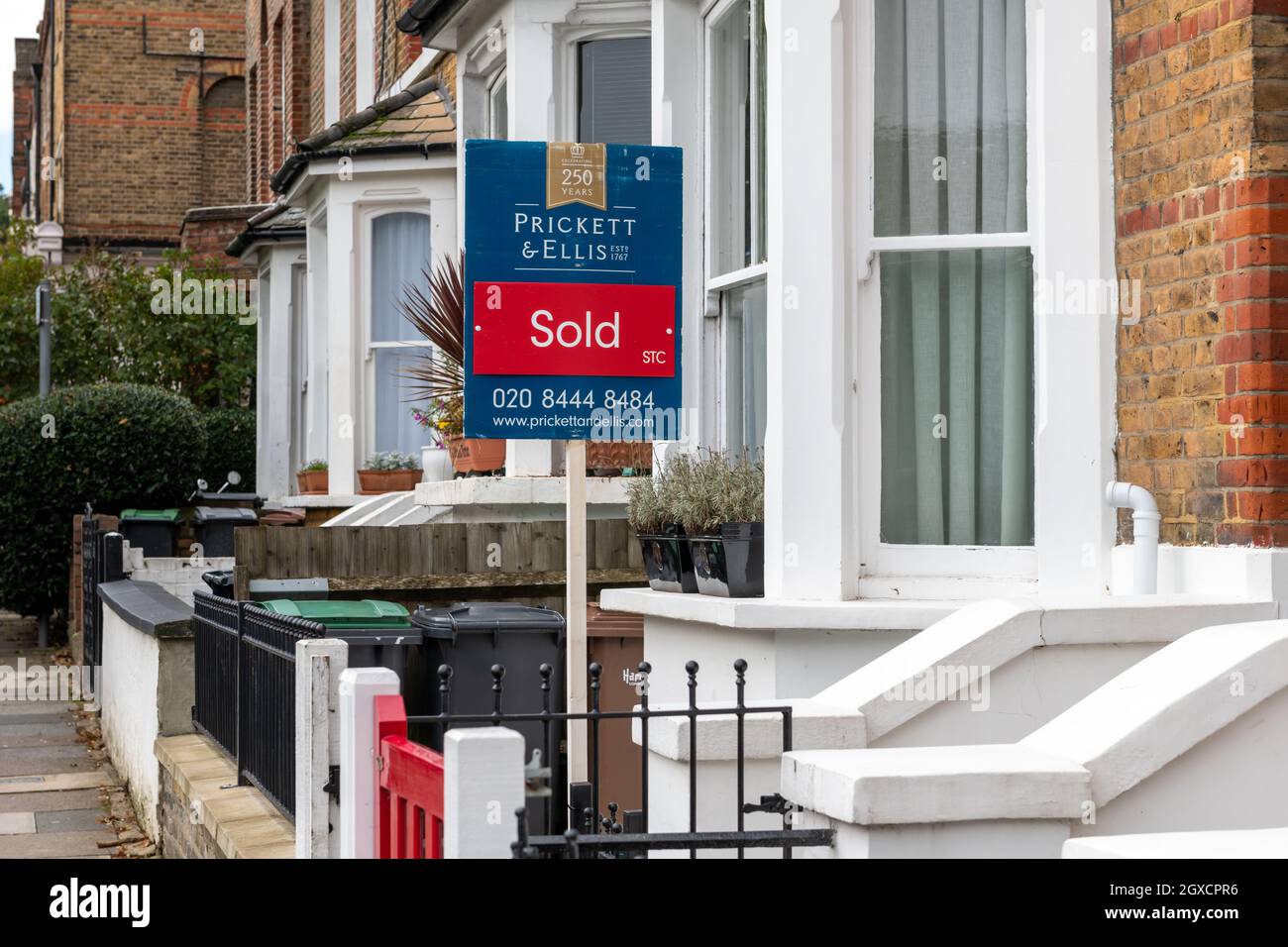 London. UK. 10.03.2021. A property sold sign outside a suburban terrace house with property prices raising dramatically in the countryside. Stock Photo