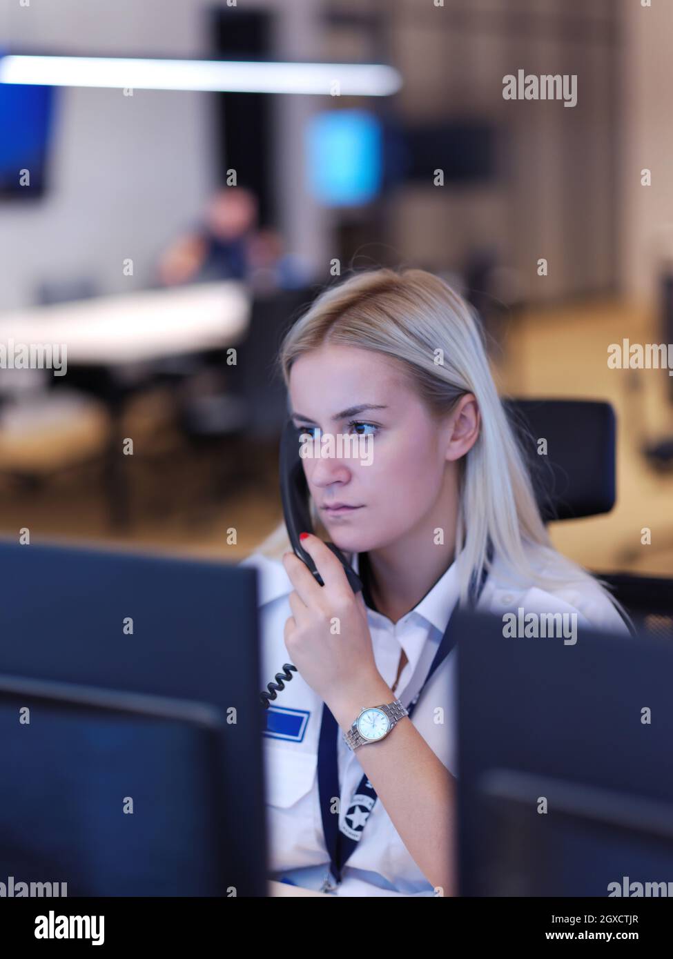 Female security guard operator talking on the phone while working at ...