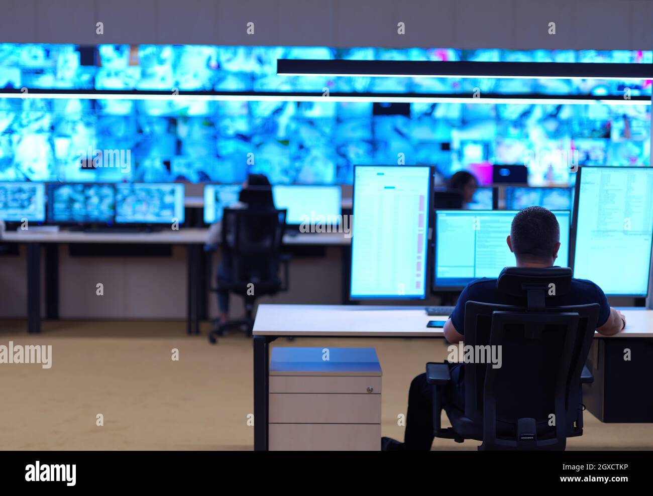 Male security operator working in a data system control room offices Technical Operator Working