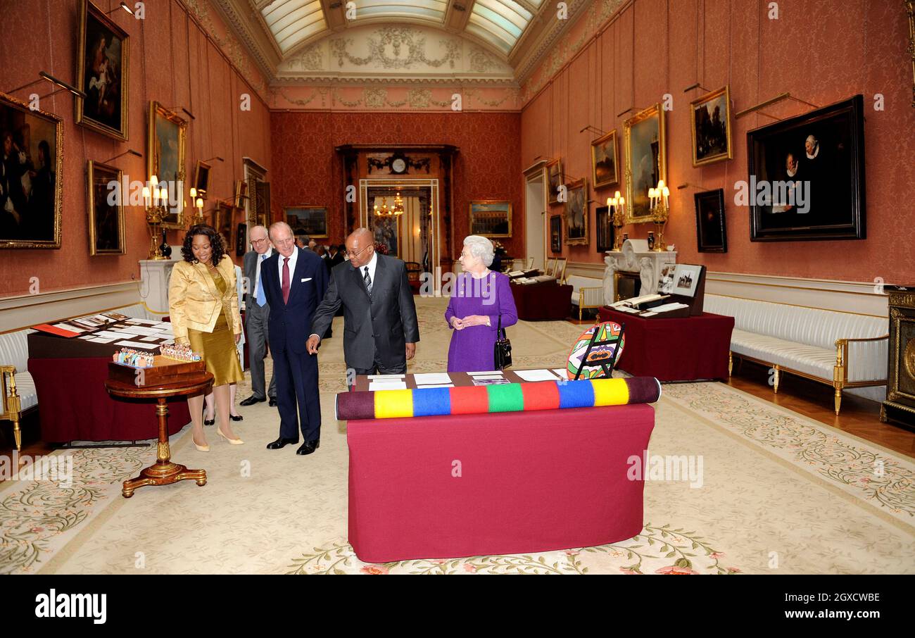 Britain's Queen Elizabeth II, Prince Philip, Duke of Edinburgh, President of South Africa Jacob Zuma and Mrs Zuma look at a woollen blanket woven in the colours of South Africa, part of an exhibition of South African related items at Buckingham Palace in London as part of the President's three-day state visit. Stock Photo