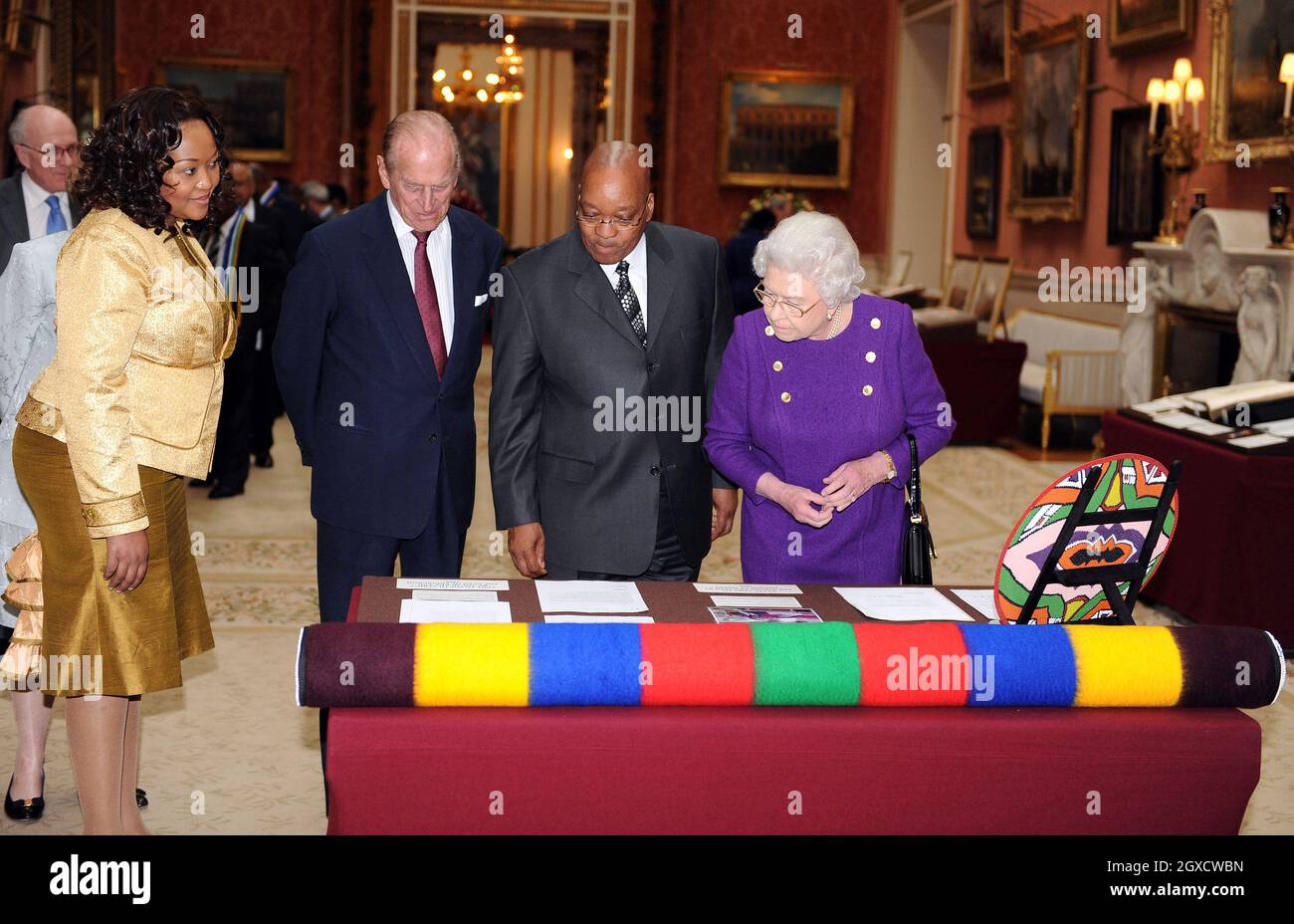 Britain's Queen Elizabeth II, Prince Philip, Duke of Edinburgh, President of South Africa Jacob Zuma and Mrs Zuma look at a woollen blanket woven in the colours of South Africa, part of an exhibition of South African related items at Buckingham Palace in London as part of the President's three-day state visit. Stock Photo