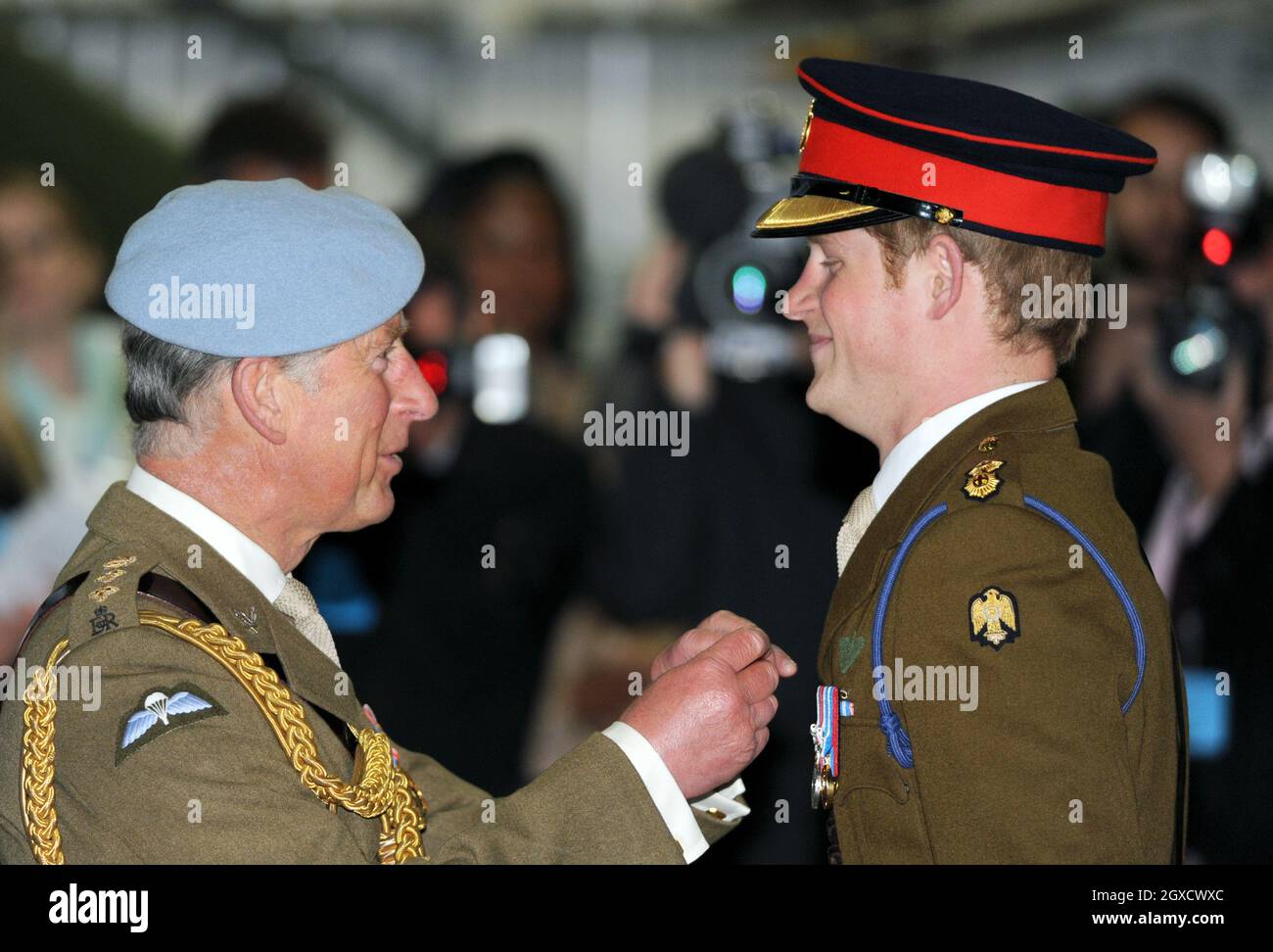 Prince Charles, Prince of Wales presents Prince Harry with his flying wings at Prince Harry's pilot course graduation at the Army Aviation Centre on May 7, 2010. The Prince will learn to fly Apache helicopters during the next part of his training.  Stock Photo