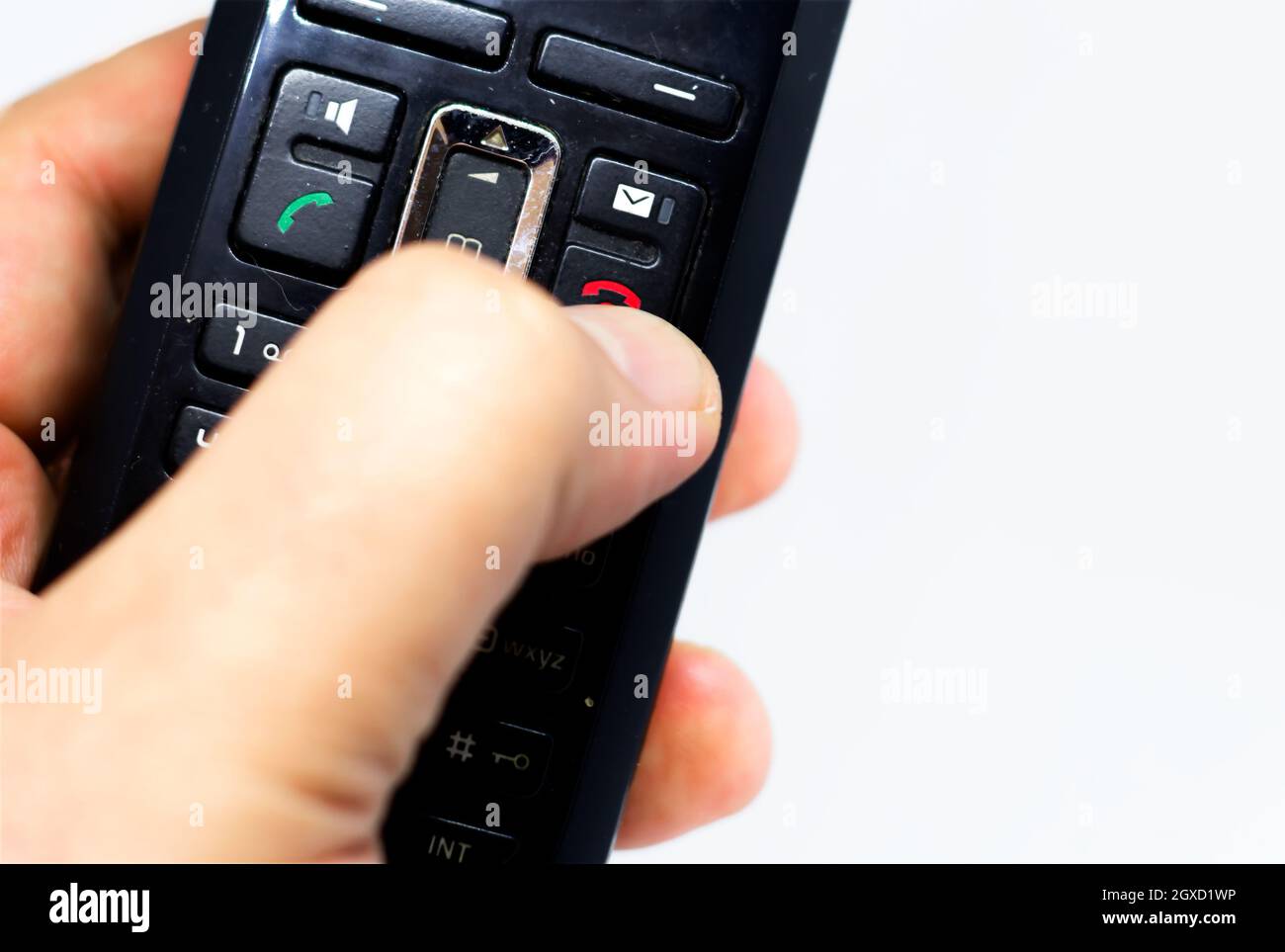 Thumb pushing the button with the red icon to reject or hang up a call