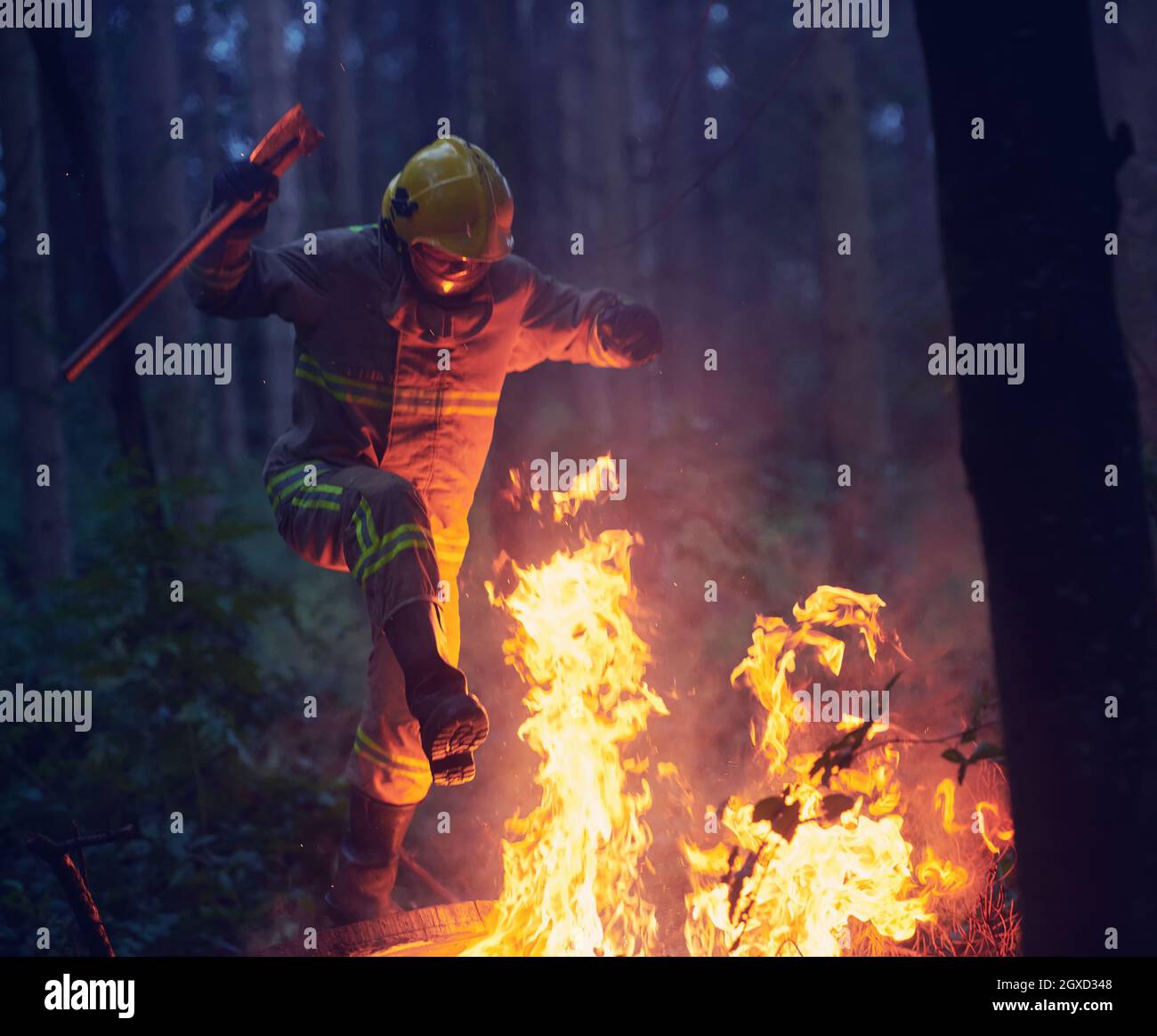 firefighter hero in action danger jumping over fire flame to rescue and ...