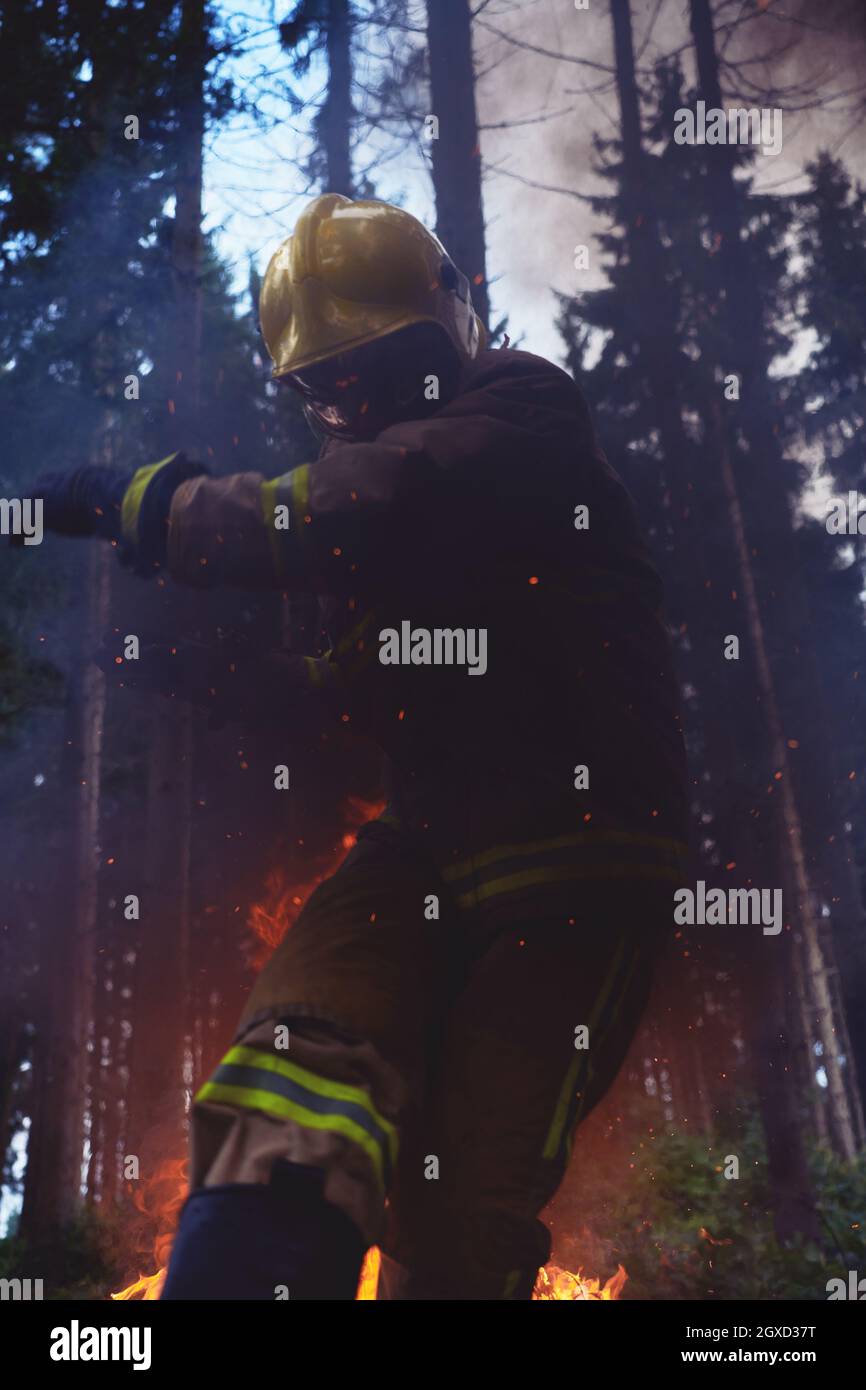 firefighter hero in action danger jumping over fire flame to rescue and ...