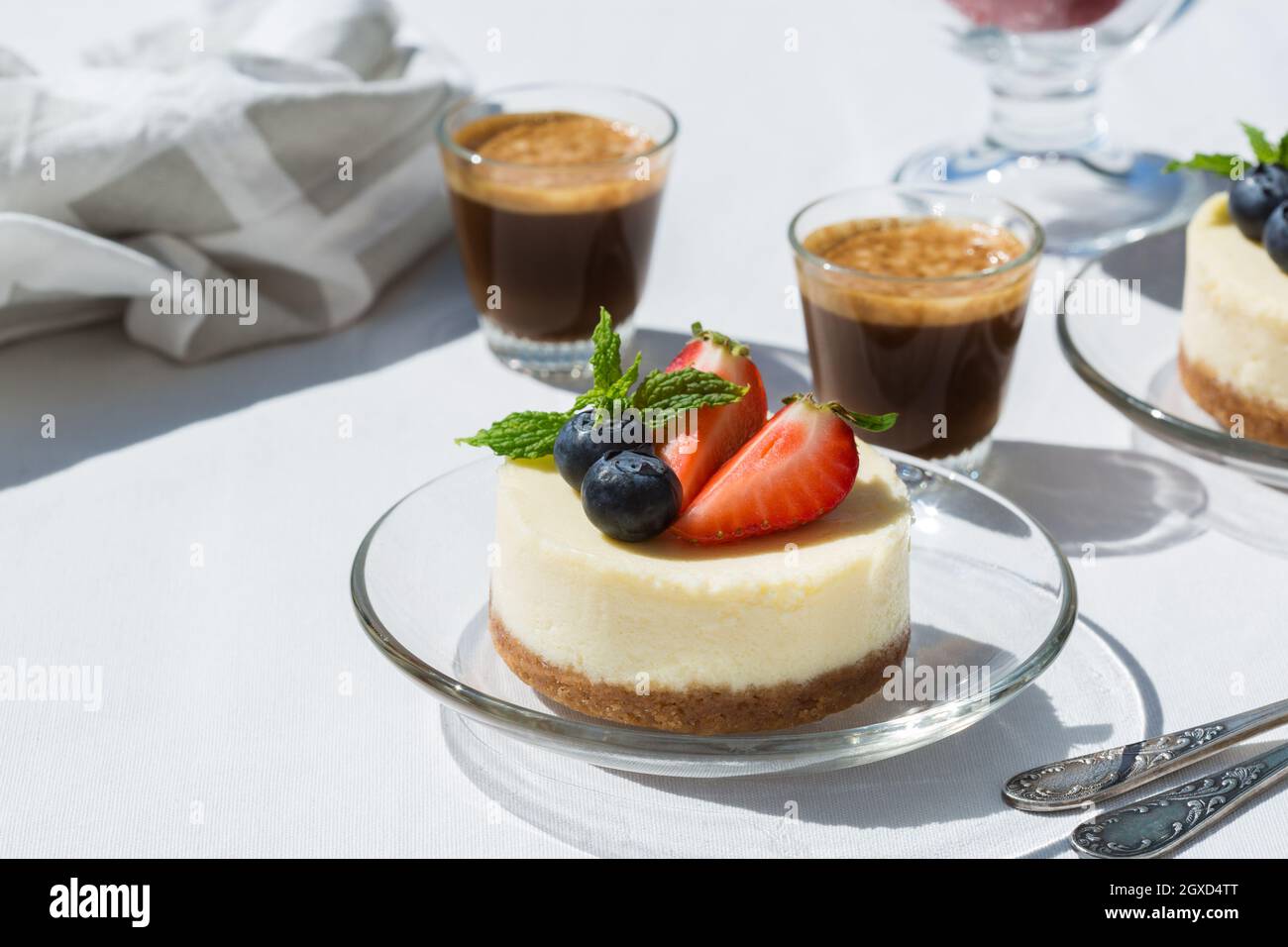 Tasty cheesecakes with fresh strawberries and blueberries under mint